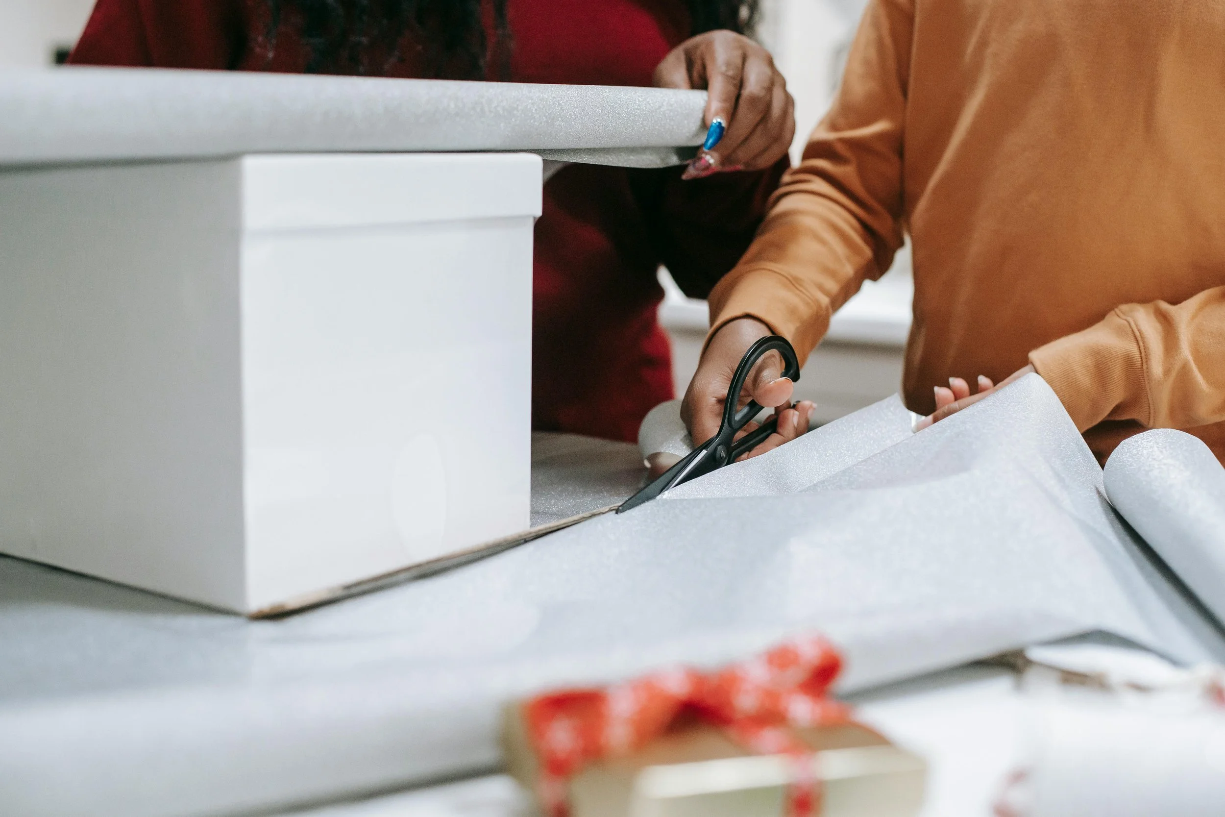 Woman preparing a present with wrapping paper and ribbon