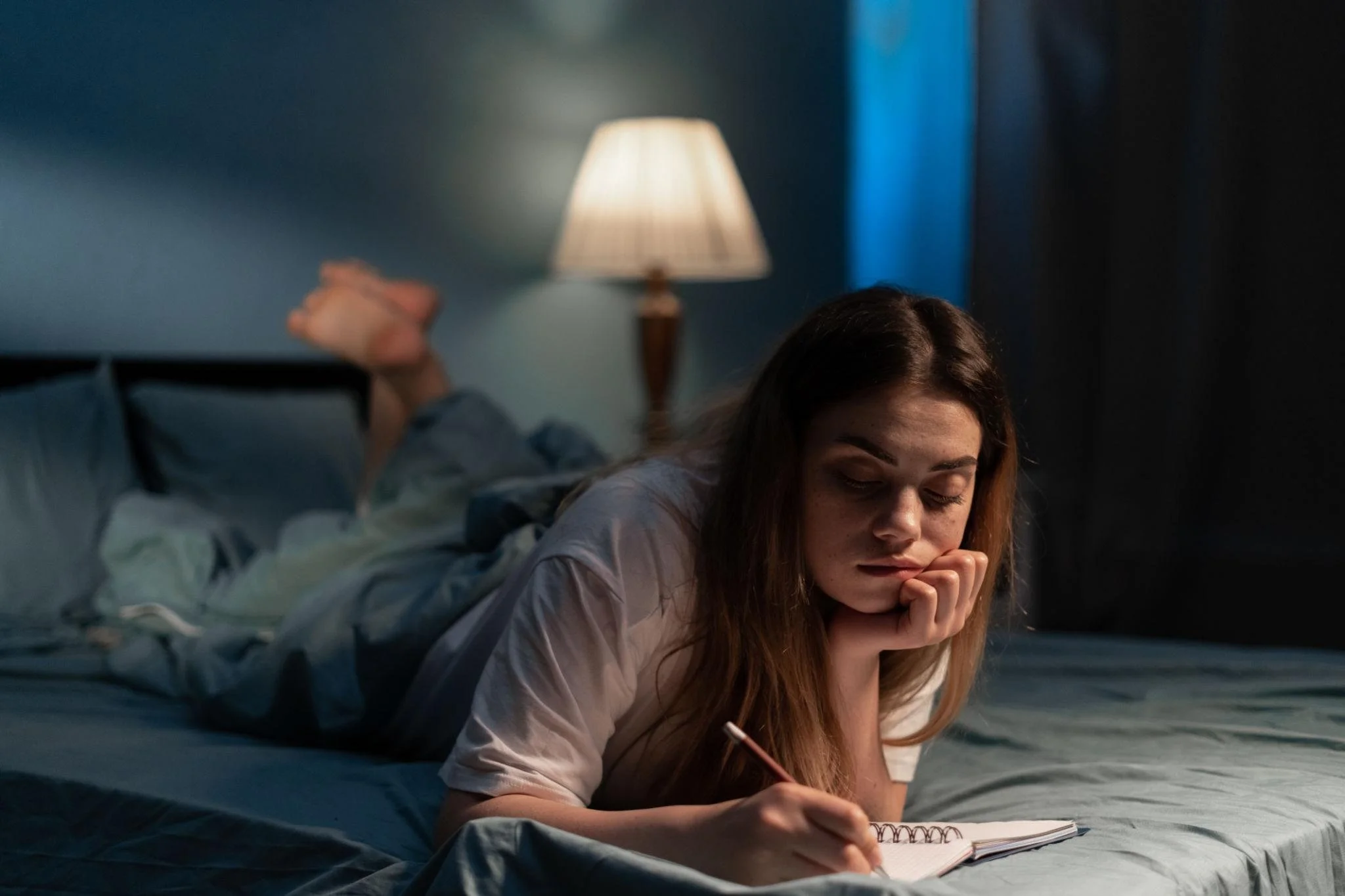Adult journaling at night to process worries and reduce bedtime anxiety.