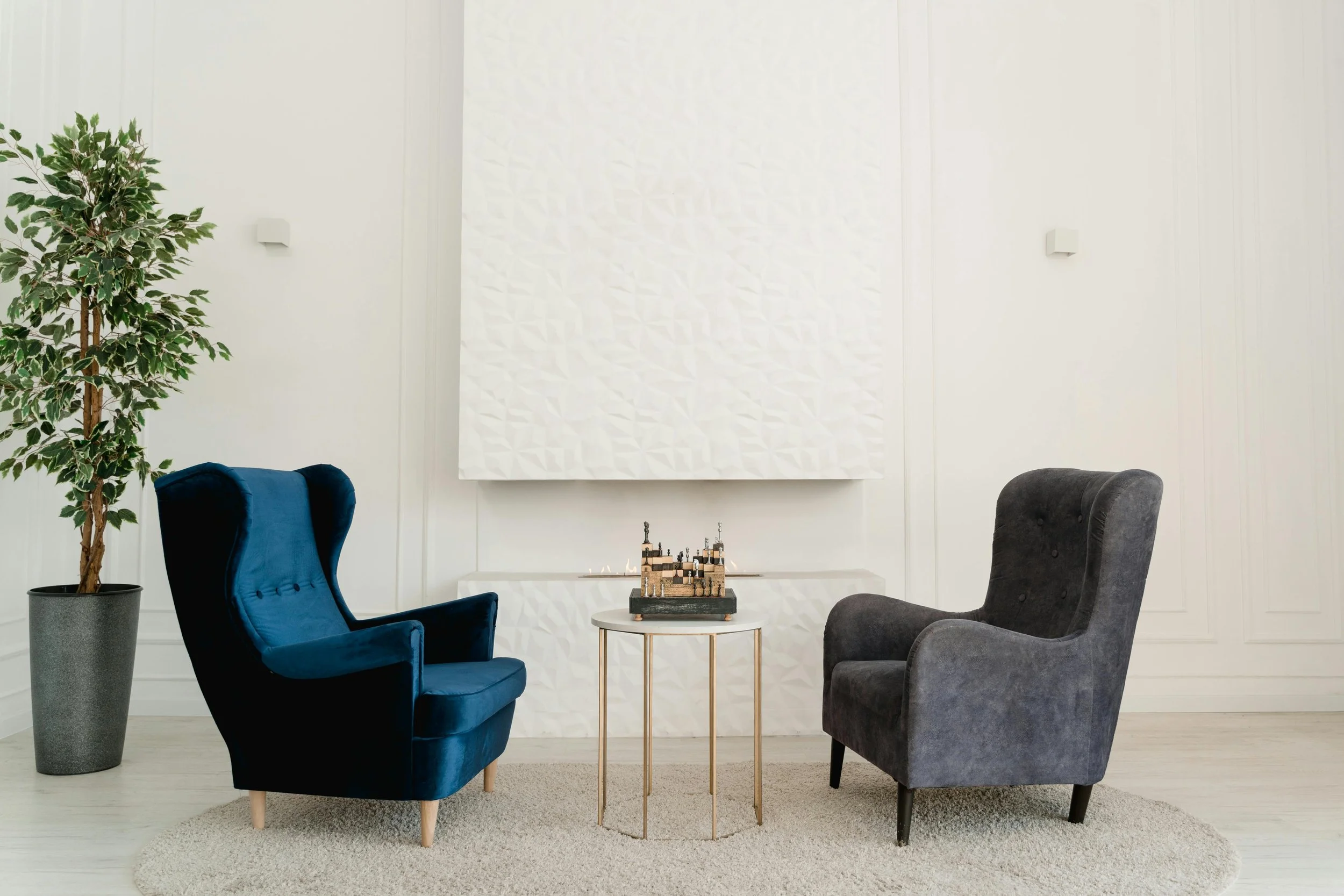 A warm and inviting therapy office with soft lighting, a comfortable armchair, a small couch, indoor plants, and calming decor creating a cozy, welcoming atmosphere