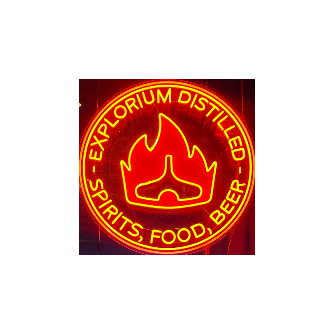 Neon sign for Explorium Distilled, featuring a flame and a campfire with the words 'Spirits, Food, Beer'.