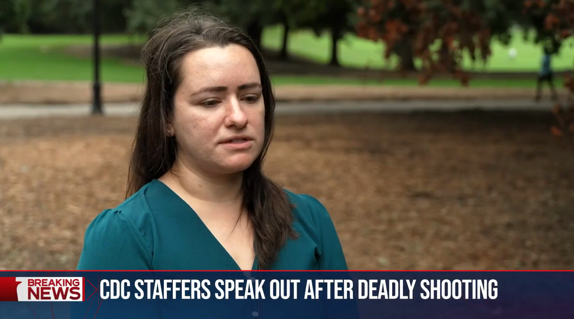 A woman with long brown hair wearing a teal top for a news interview outdoors with trees and grass in the background, a caption reads 'CDC staffers speak out after deadly shooting'.