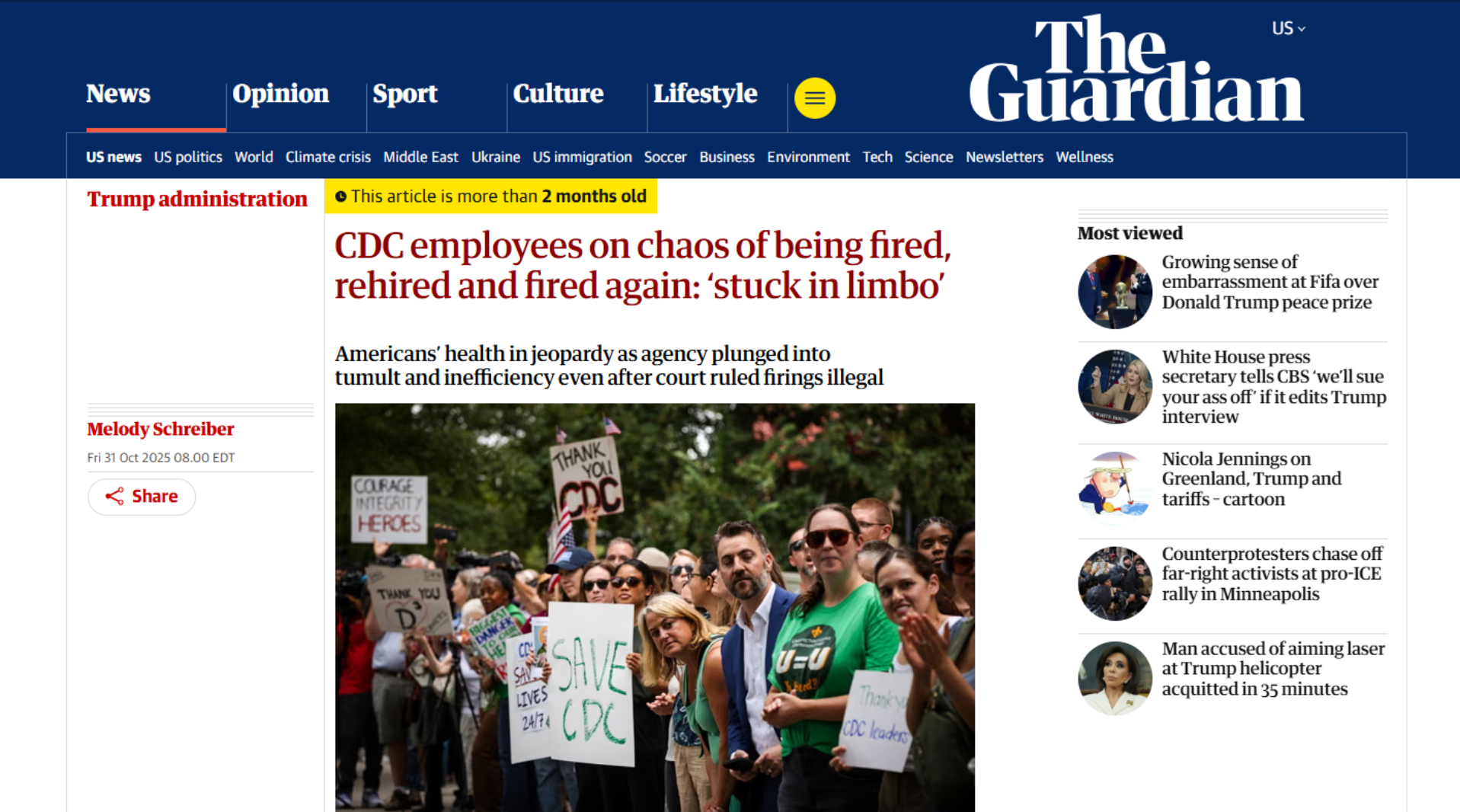 A group of protesters holding signs, some of which read 'SAVE CDC,' 'THANK YOU CDC,' and 'COURAGE INTEGRITY HEROES,' gathered outdoors during a demonstration. The protesters include men and women of various ages, some wearing sunglasses, with trees in the background.