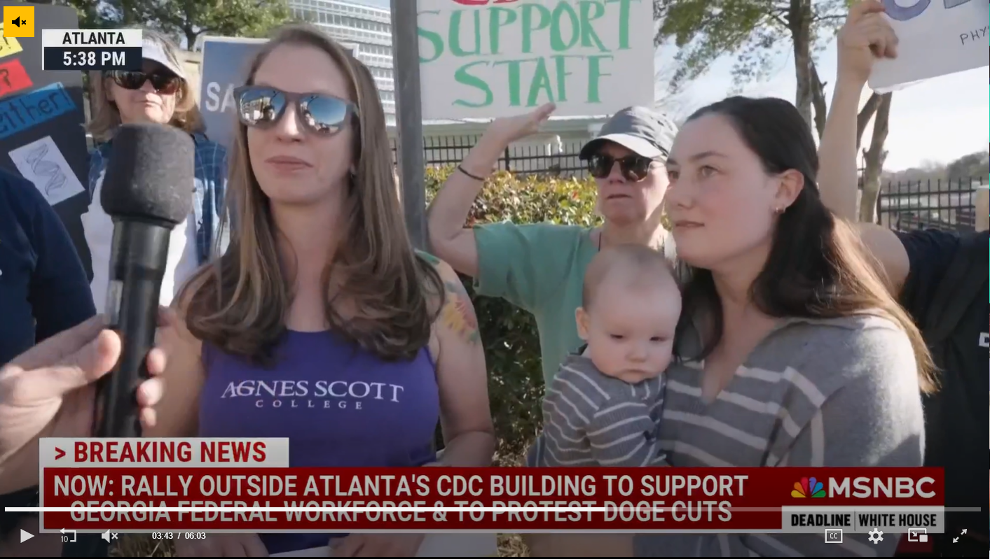 Protestors gather outside the CDC building in Atlanta supporting staff, with signs including one that says "Support Staff," as part of a rally against COVID-19 vaccine mandates and for protest against the dismantling of CDC, during a news broadcast.