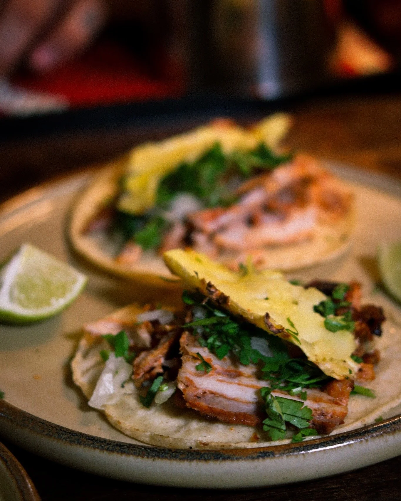 Two tacos. No filler. No fanfare.
Corn tortilla pressed daily, pastor carved fresh off the trompo, pi&ntilde;a sliced to order.
The cilantro still bright. The onion crisp. The lime, untouched until you decide.
This is what we mean when we say we don'