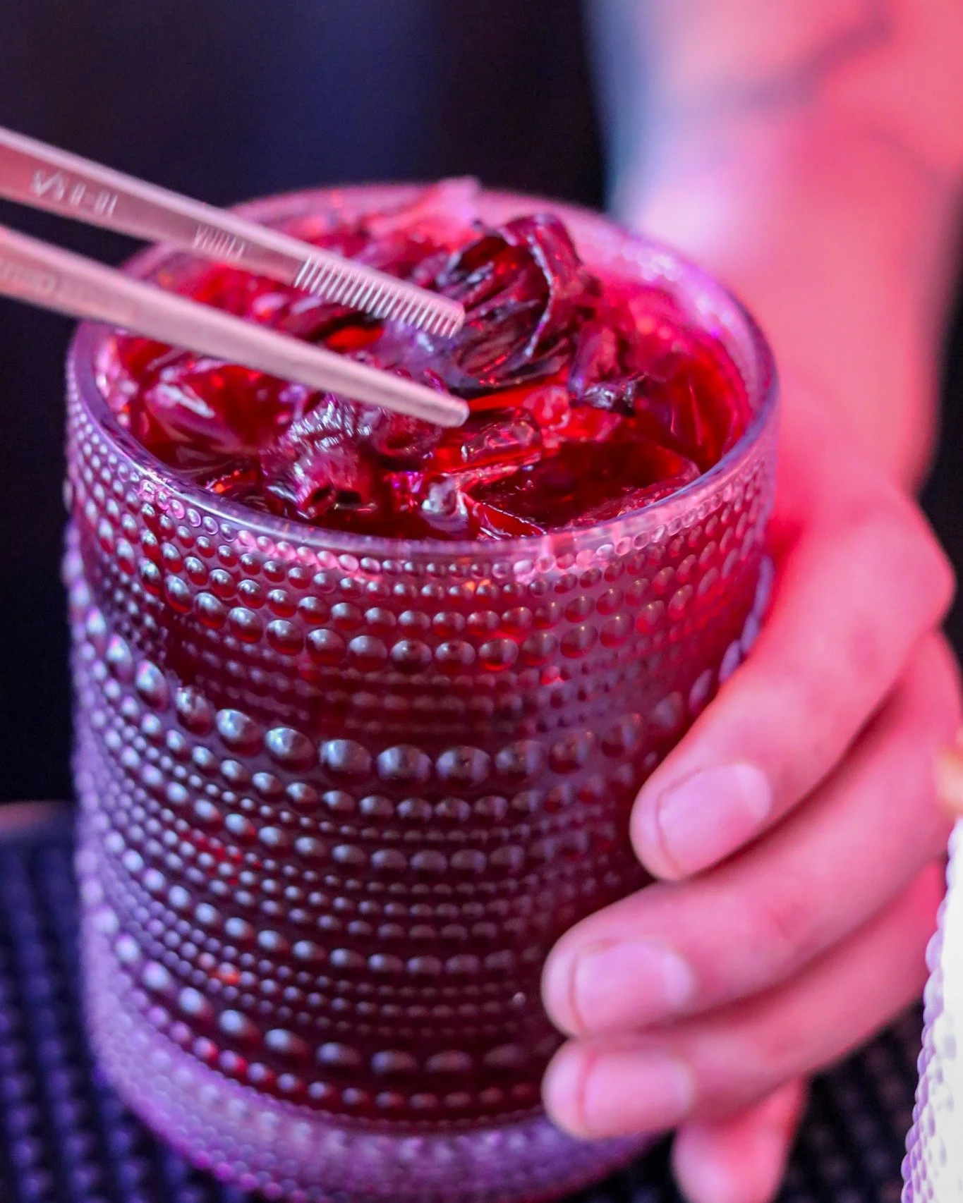 Deep ruby red, served in textured glass, built with intention. 🍷🌺
That jewel-toned pour over fresh ice &mdash; likely our jamaica-forward build &mdash; gets stirred and finished by hand, the way every drink crosses our bar.
No premix, no shortcuts.