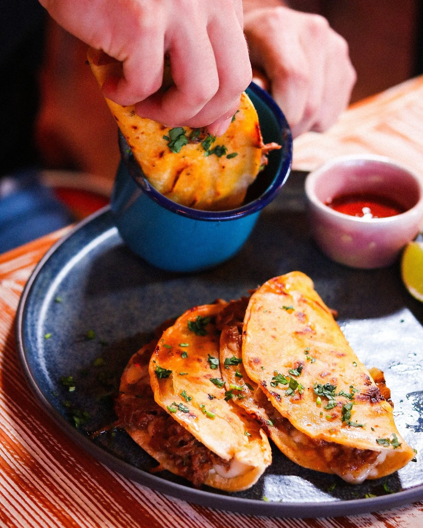 The dip is the whole point. 🤜🍲
Birria tacos come with consom&eacute; for a reason &mdash; that rich, slow-simmered broth is where all the flavor lives. Dunk, bite, repeat.
Pro tip from the kitchen: dip the tortilla first, let it soak for a second, 