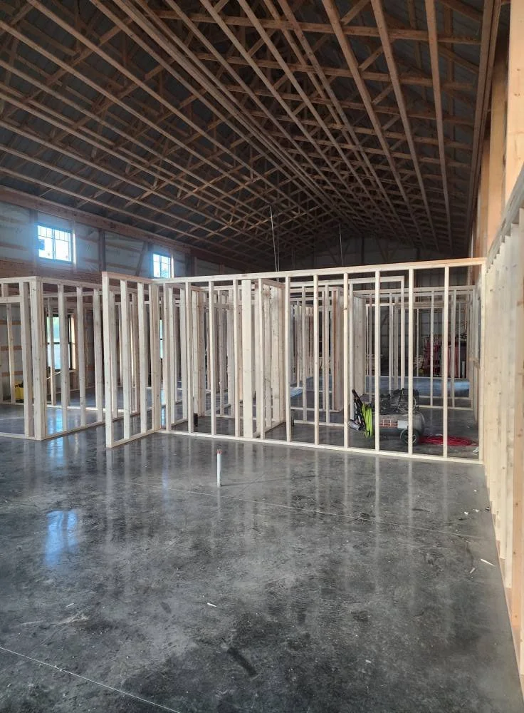 Electric utility work site with a trench containing a conduit, a metal switchgear, and a construction excavator arm.