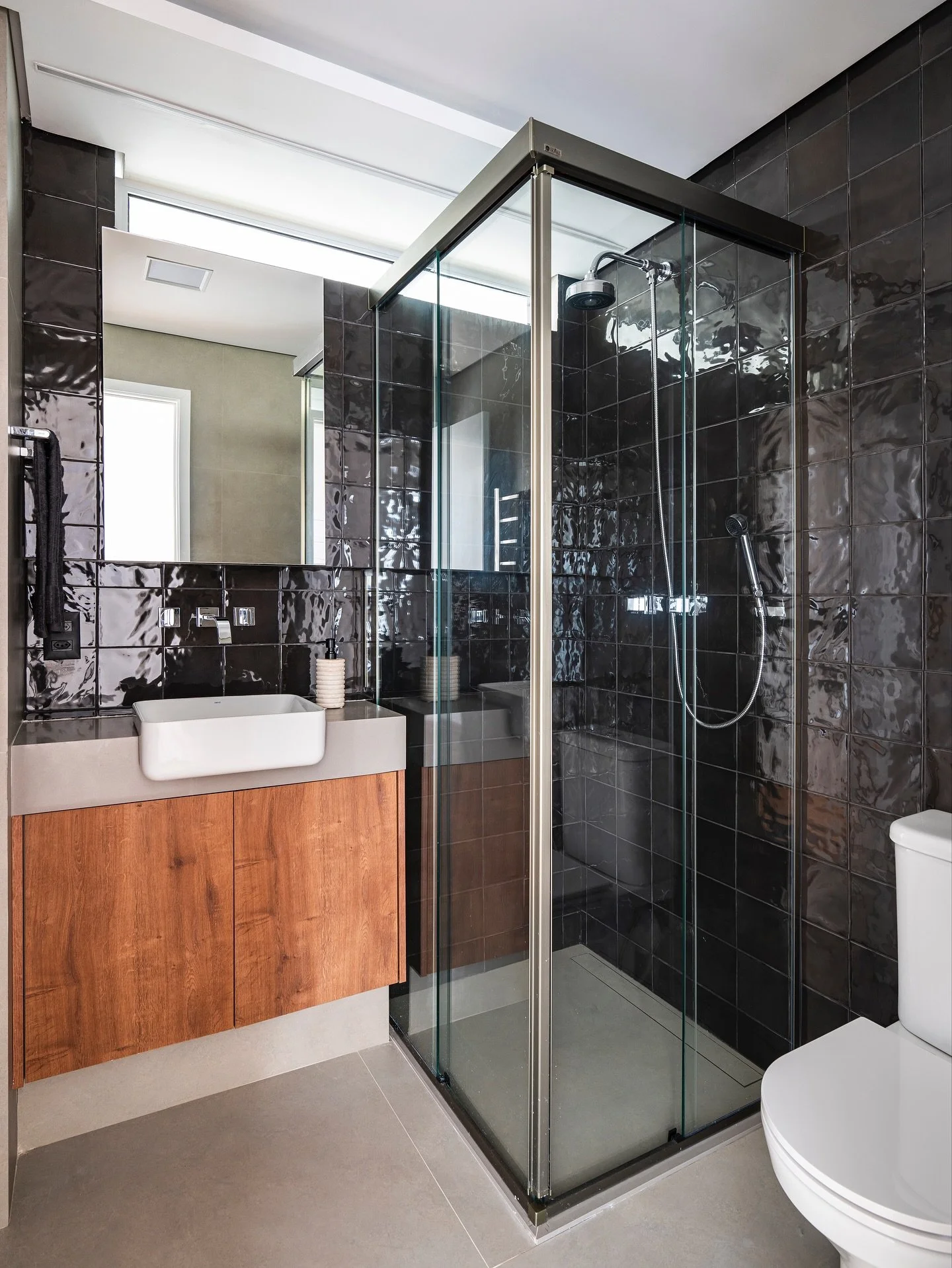 Banho social no Triplex | FKA

Este banheiro traduz a ess&ecirc;ncia do projeto: um espa&ccedil;o compacto, mas cheio de personalidade.

O revestimento em tom grafite, com brilho sutil e textura artesanal, contrasta com a marcenaria amadeirada e traz