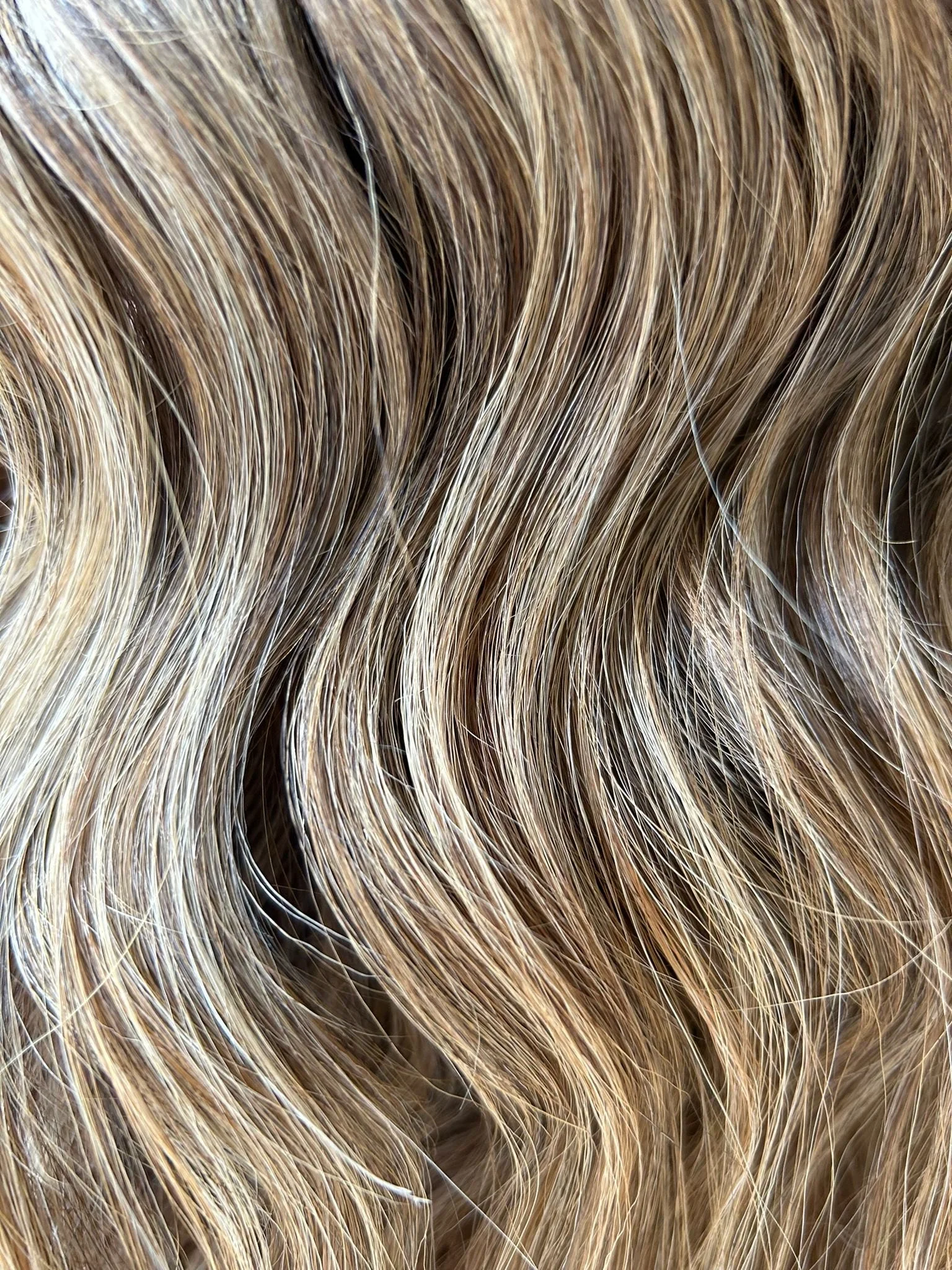 Close-up of wavy blonde hair with highlights and lowlights.