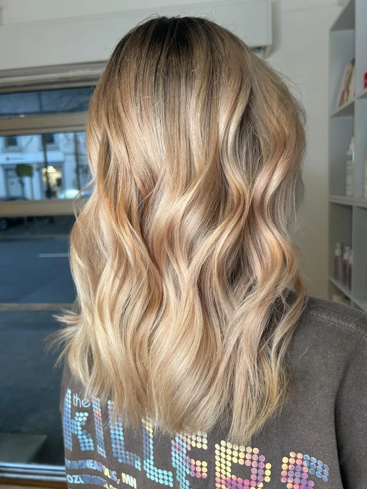 Blonde woman with wavy hair in a hairstyle salon.