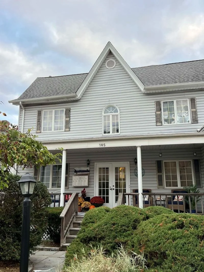 The Mandeville Mental Health Counseling office building, a historic gray home with an expansive front porch in Oyster Bay, NY.