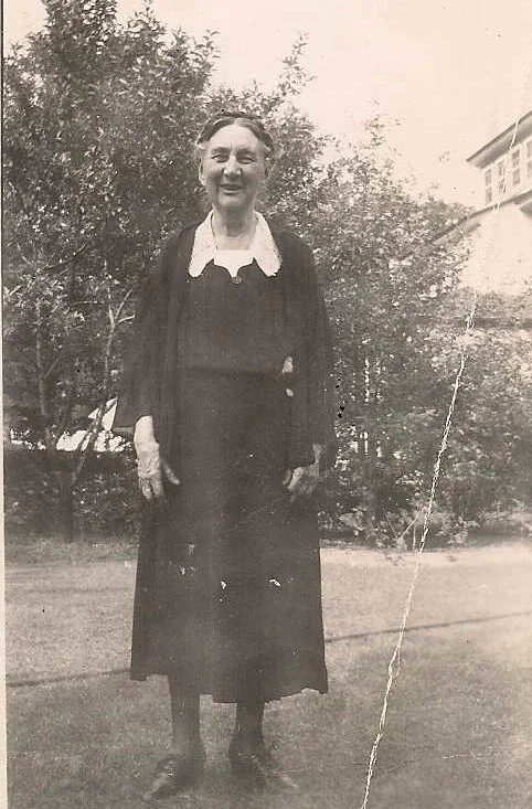 Black and white vintage photo of Ella Mandeville, elderly lady in a black dress smiling