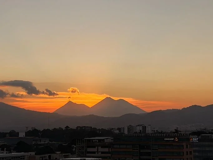 Sunset over a volcanic mountain range in a coffee-growing region.