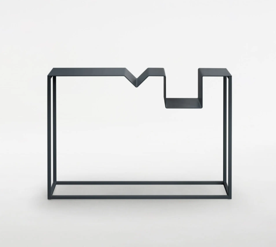A black metal geometric shelf with a unique zigzag design on top, set against a plain white background.