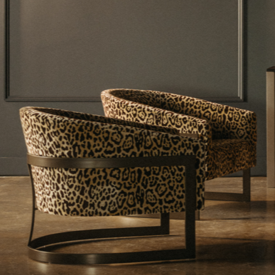 Two leopard print upholstered chairs with curved backs curated by designers at The Home Studio Collective showroom.
