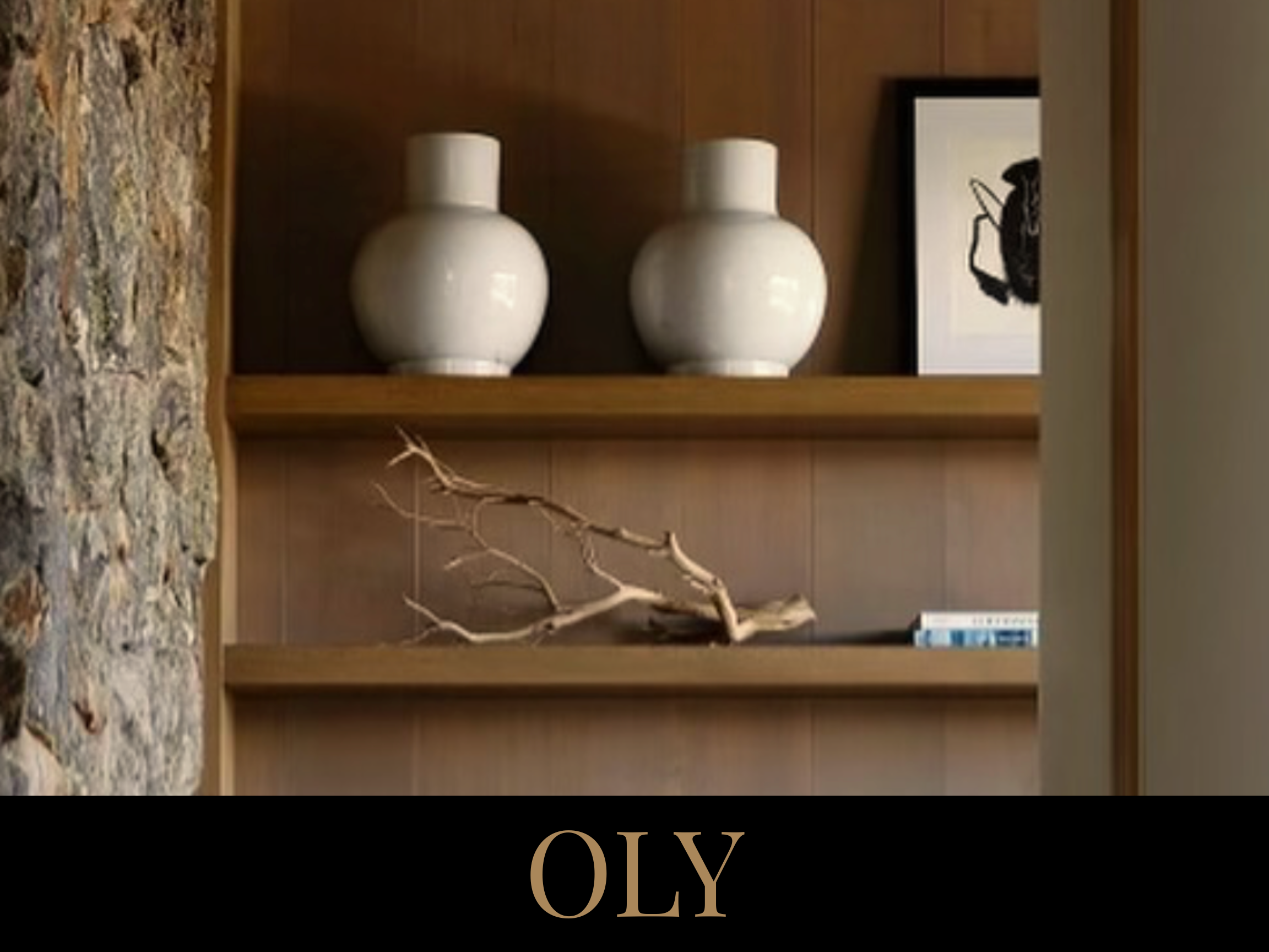 A wooden bookshelf with two white ceramic vases, a framed black and white artwork, and a decorative piece of driftwood.