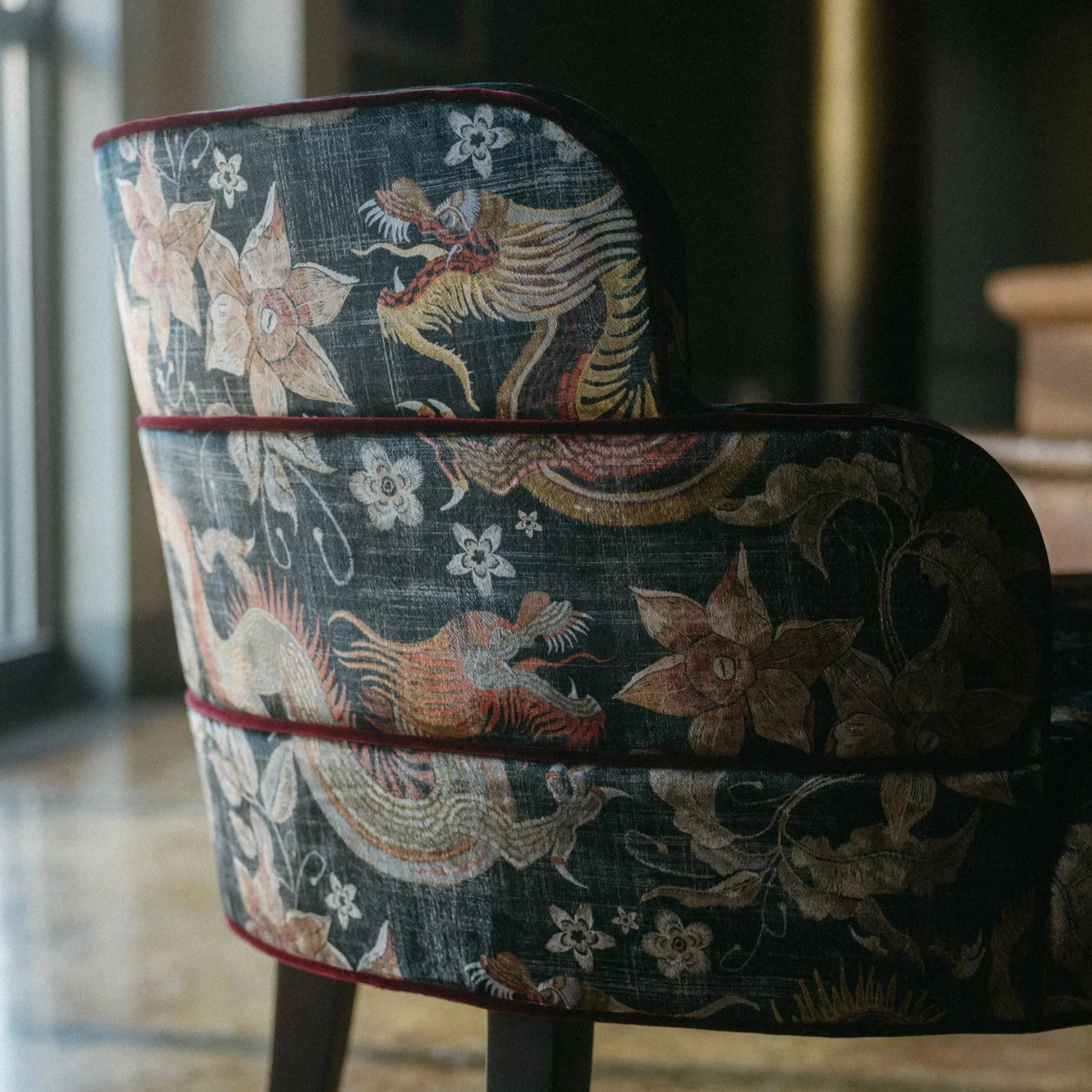 Close-up of two stacked fabric storage baskets with a traditional Asian dragon and floral pattern on a black background.