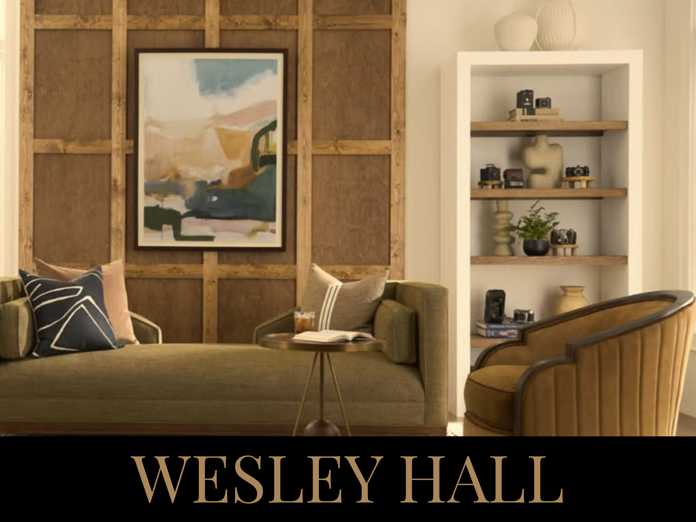 Interior of a living room with a green sofa, beige cushions, a wooden side table with a drink and open book, a brown armchair, and a white bookshelf with decorative items and cameras, against a wood-paneled wall. The text "WESLEY HALL" is at the bott