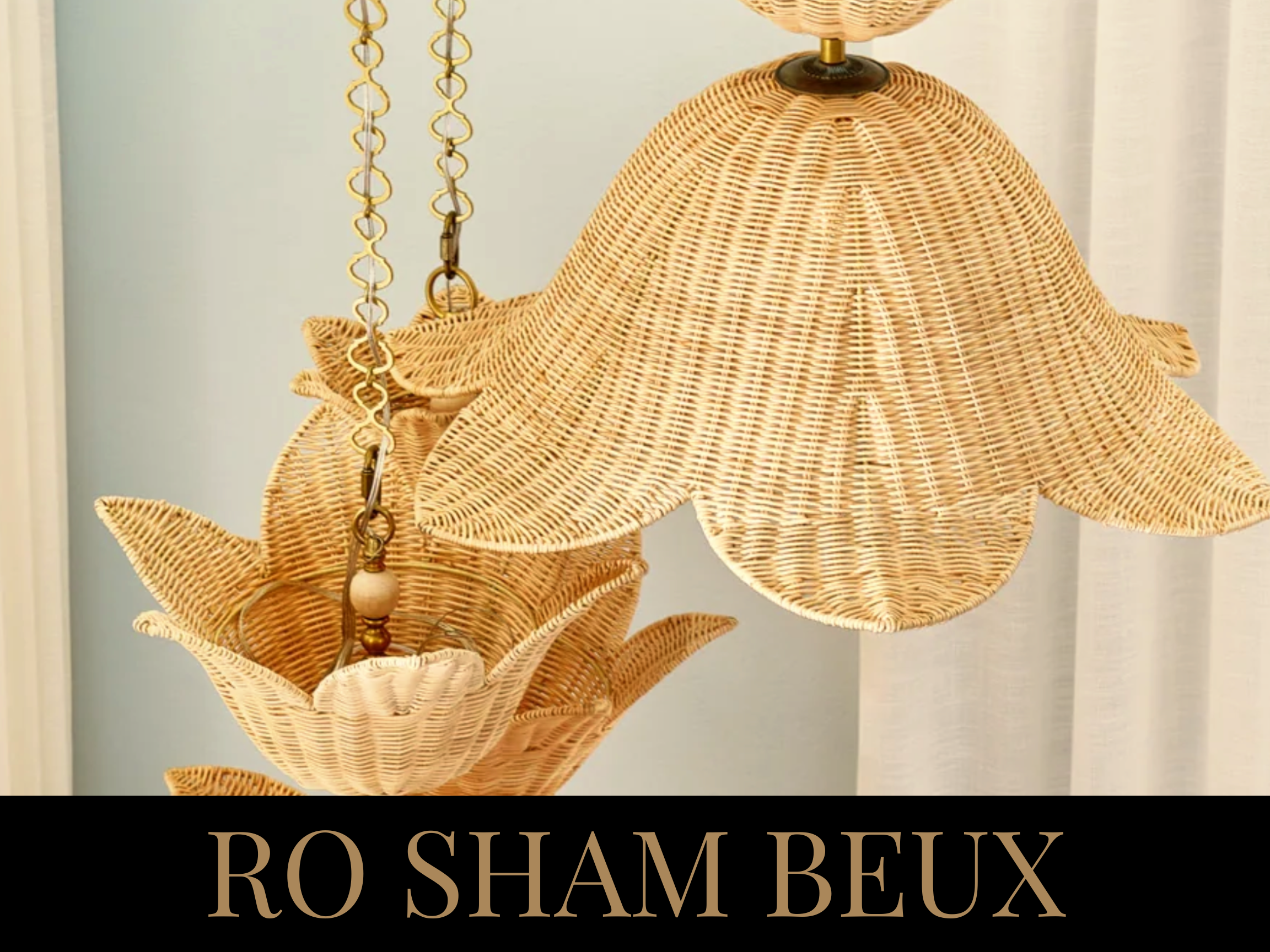 Close-up of a wicker chandelier with leaf-shaped shades hanging on a light-colored wall.