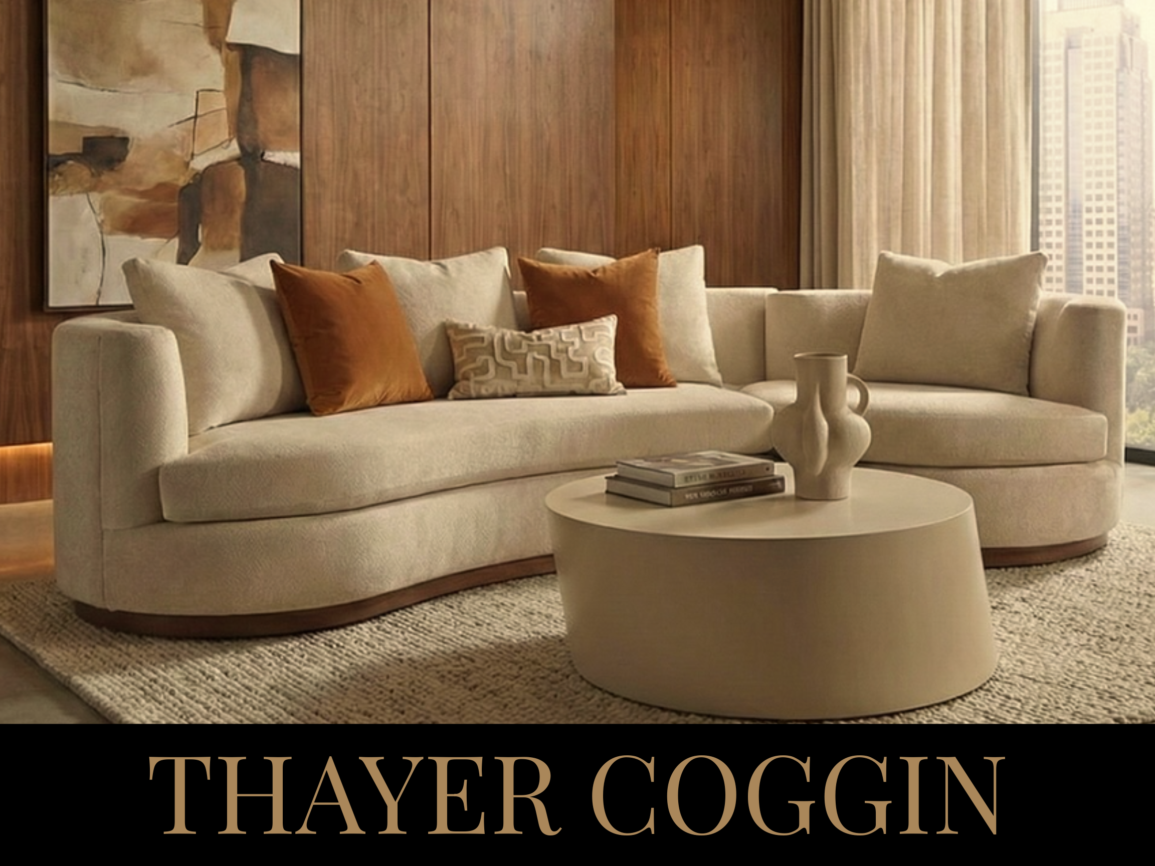 Modern living room with a curved beige sofa, brown and beige throw pillows, a round white coffee table, and a wood-paneled wall with artwork. Large windows with beige curtains reveal a city view.