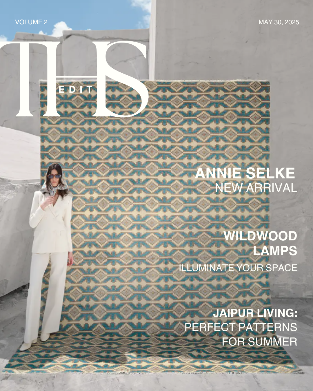 Magazine cover featuring a woman in a white suit with sunglasses, standing beside a patterned rug with geometric designs in blue, beige, and white, set against a concrete background outdoors under a partly cloudy sky. The cover includes headlines about home decor, fashion, and lifestyle, with titles like "This Edition," "Annie Selke New Arrival," "Wildwood Lamps," "Illuminate Your Space," and "Jaipur Living: Perfect Patterns for Summer."