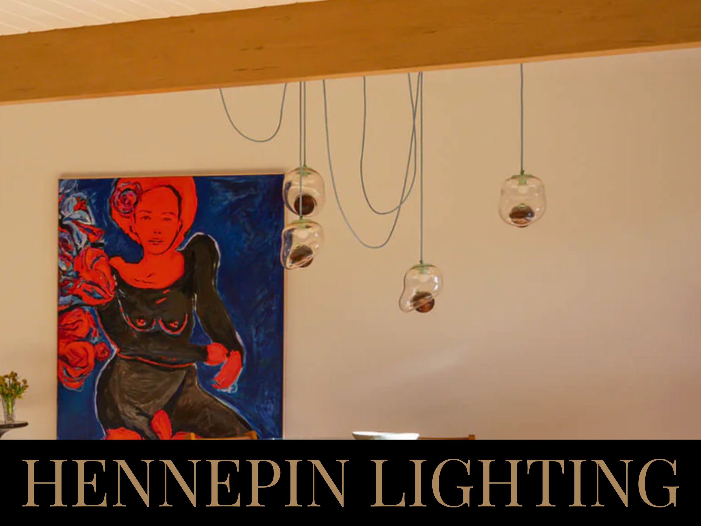 A modern art portrait of a woman with short hair, surrounded by red roses, hanging on a cream-colored wall, with three hanging glass pendant lights above. Text overlay reads "HENNEPIN LIGHTING".