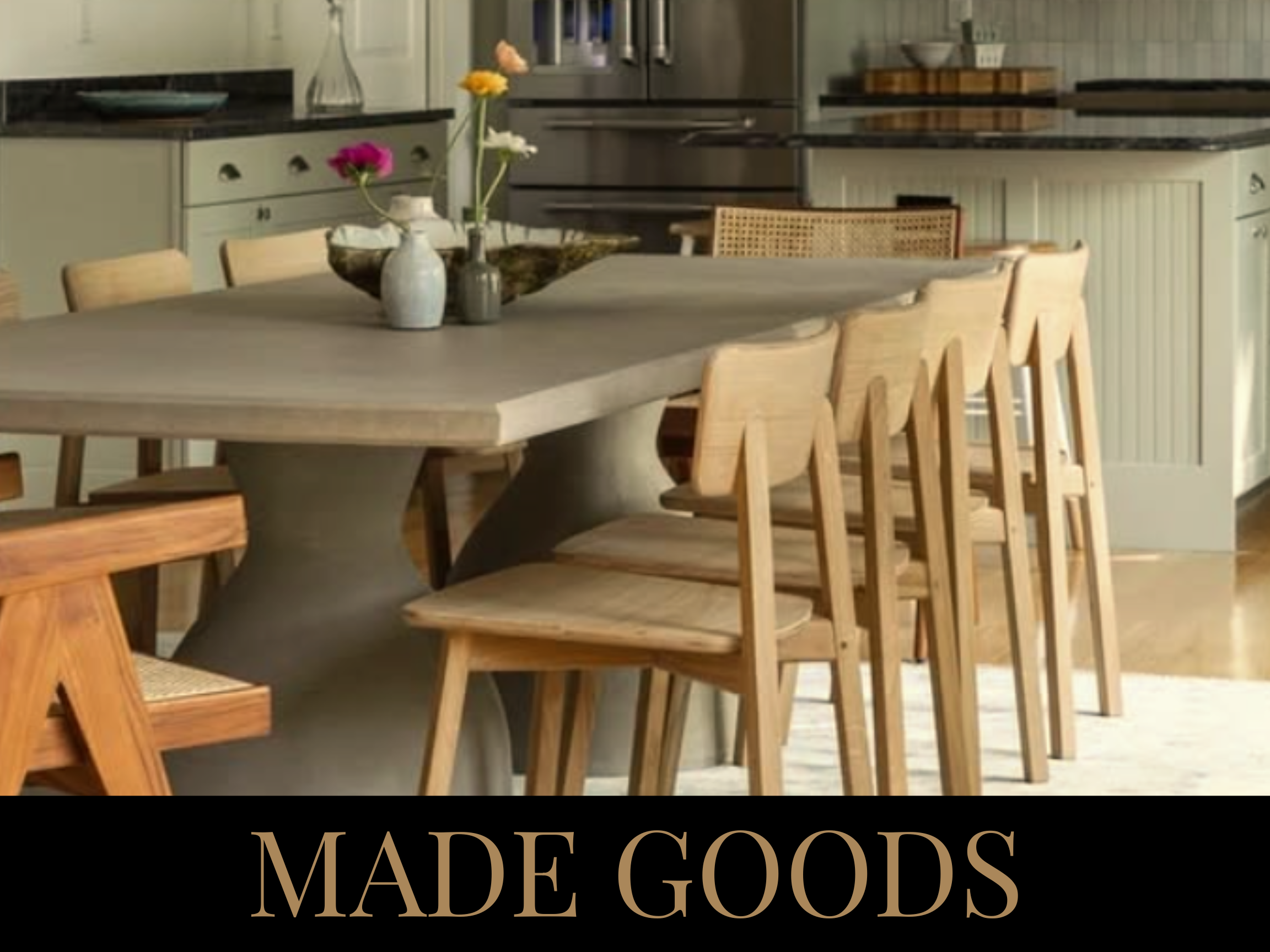 A kitchen with a large dining table surrounded by wooden chairs, and a vase with flowers as a centerpiece.