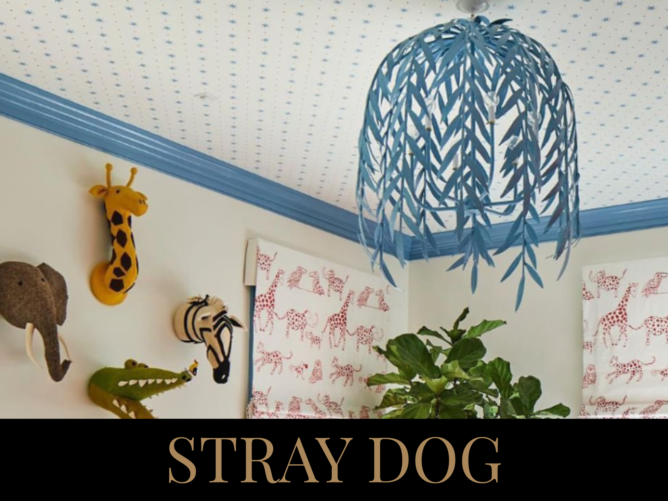 Decorative room with stuffed animal safari animals on the wall, a blue leaf-shaped hanging light fixture, and giraffe patterned curtains. There is also a large green plant in the room.