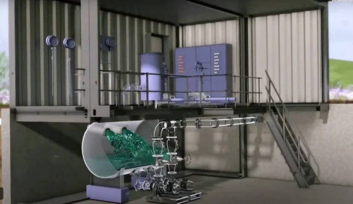 A laboratory setup with water flowing from a large pipe into a series of smaller connected pipes and machinery inside a metal shipping container.