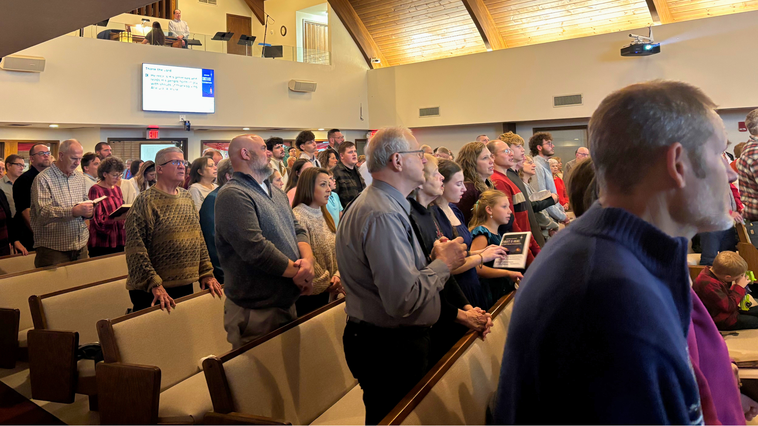 Members of Redeemer Lutheran Church singing hymns together during worship, lifting their voices in praise and celebrating God’s love.