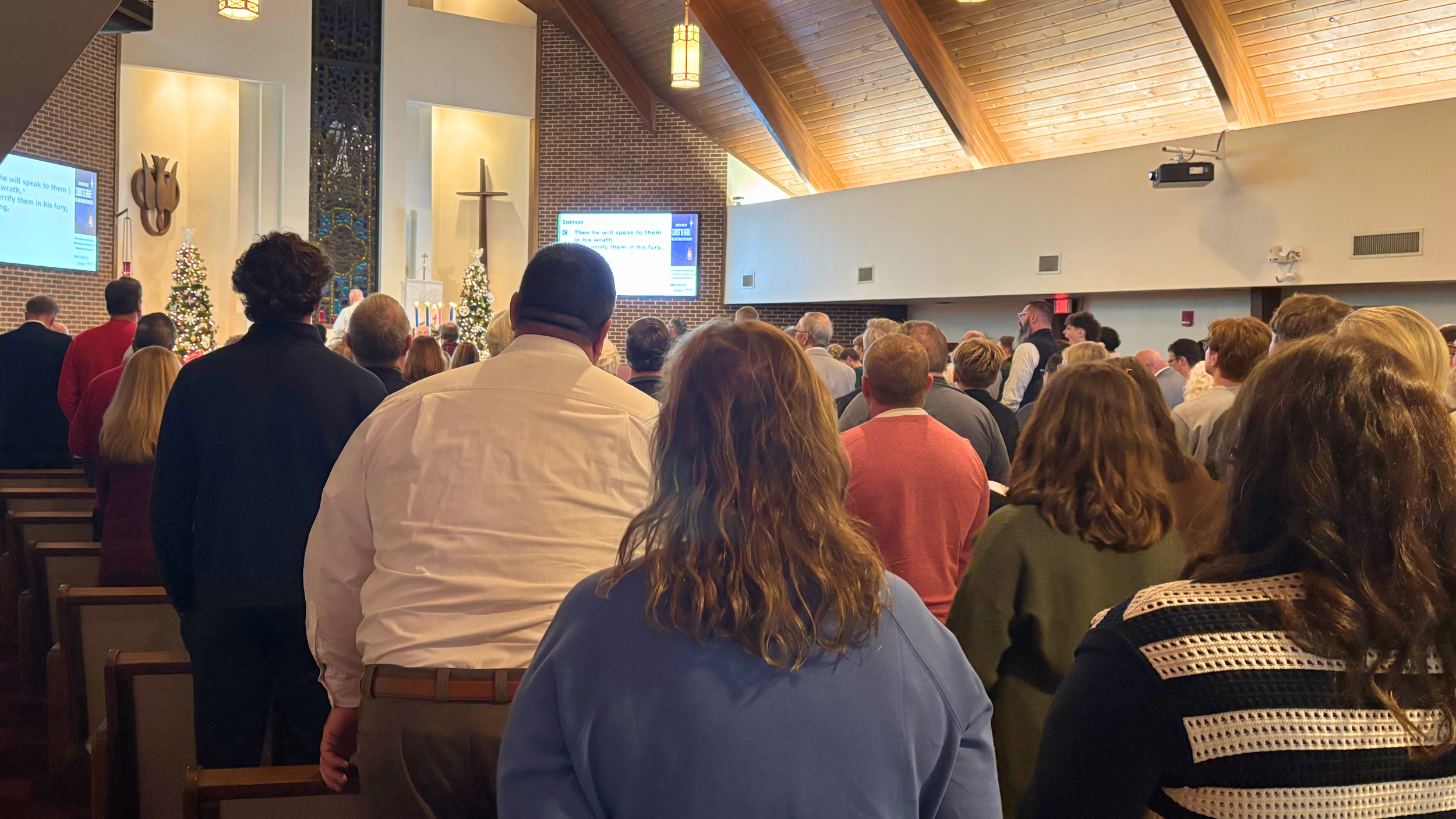 Members of Redeemer Lutheran Church lighting candles during the Christmas service, creating a warm and reverent atmosphere in the sanctuary.