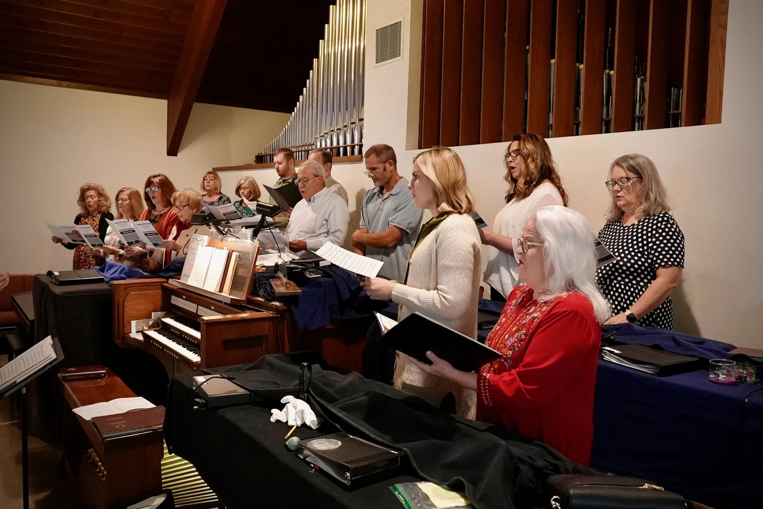 Redeemer Lutheran Church music ministry: Choir members singing and following sheet music during worship, enhancing the congregation’s worship experience with harmonies and live music.