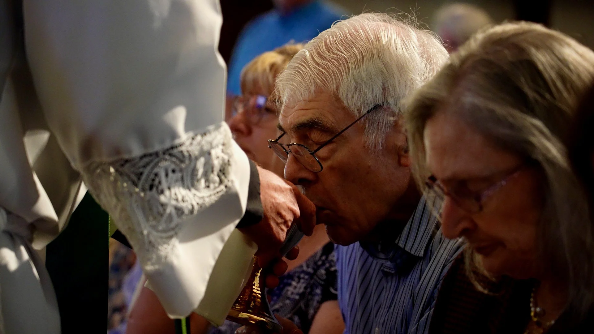 Two congregants at Redeemer Lutheran Church bowing their heads in prayer during a worship service.