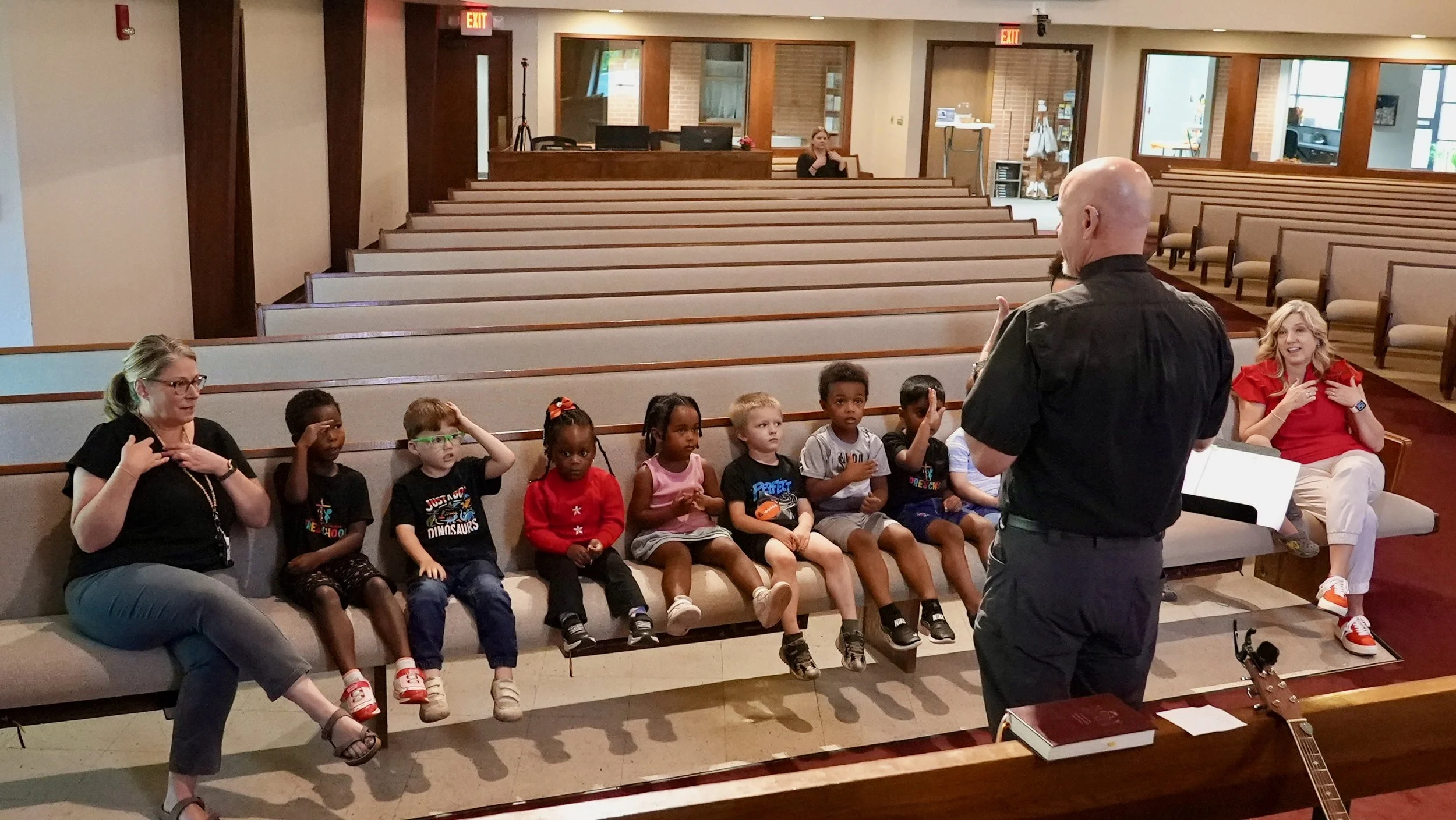 Pastor Kahle at Redeemer Lutheran Church engaging with a group of children during a church activity, with two teachers assisting the group.