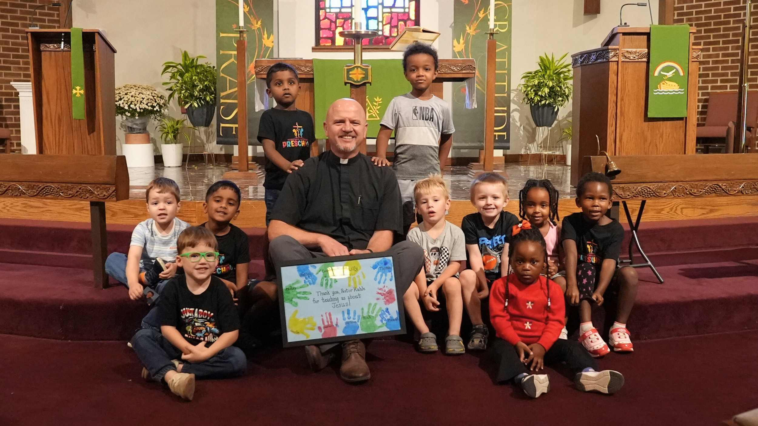 Pastor Kahle engaging with children from Redeemer Lutheran Preschool, teaching them about God’s love and the story of Christ’s birth.