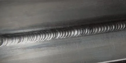 Close-up of a metal weld bead on a steel surface.