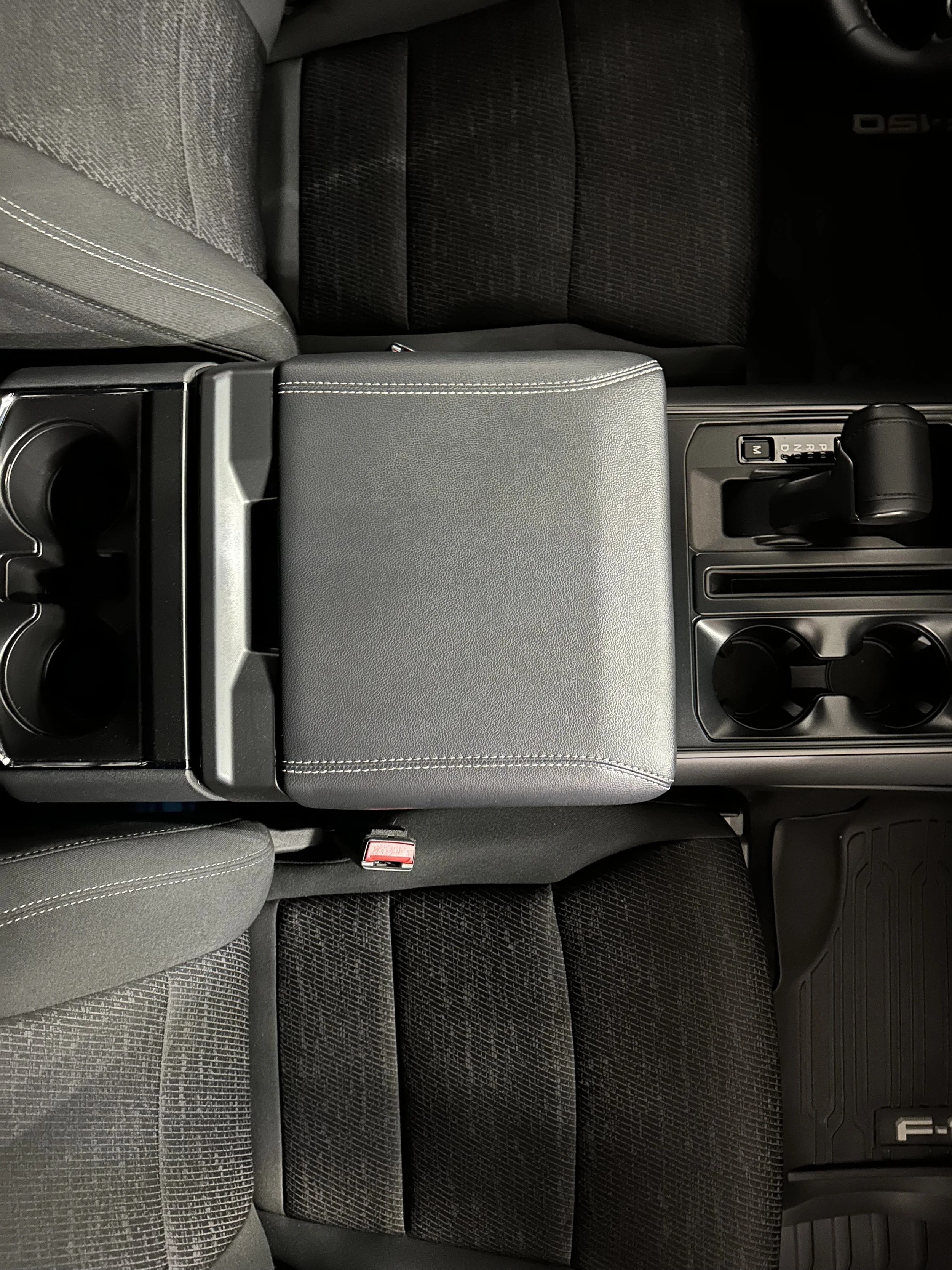Ford F-150 interior and center console detail showcasing stain removal, thorough vacuuming, plastic conditioning, and a fresh, uniform finish. Expert pickup truck interior detailing services.