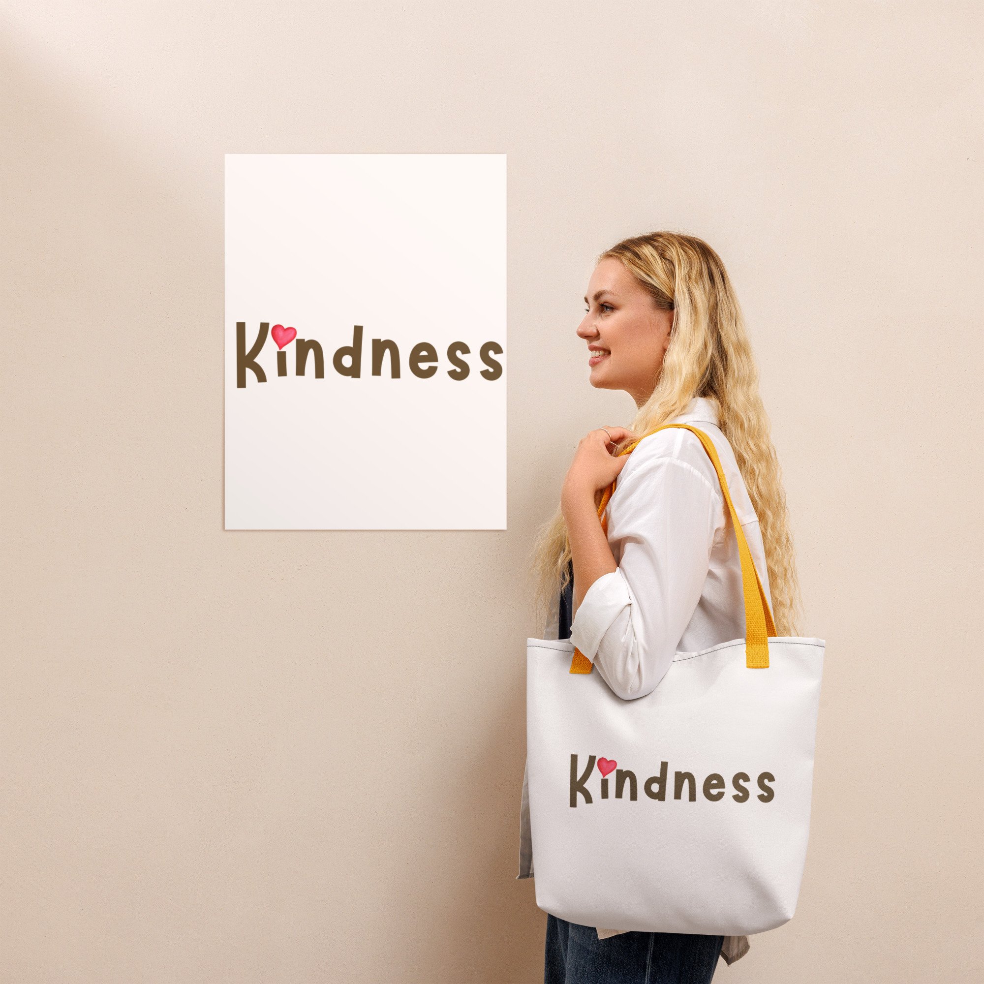 Lifestyle: woman wearing yellow-handle tote—“Kindness” wordmark by wall poster.