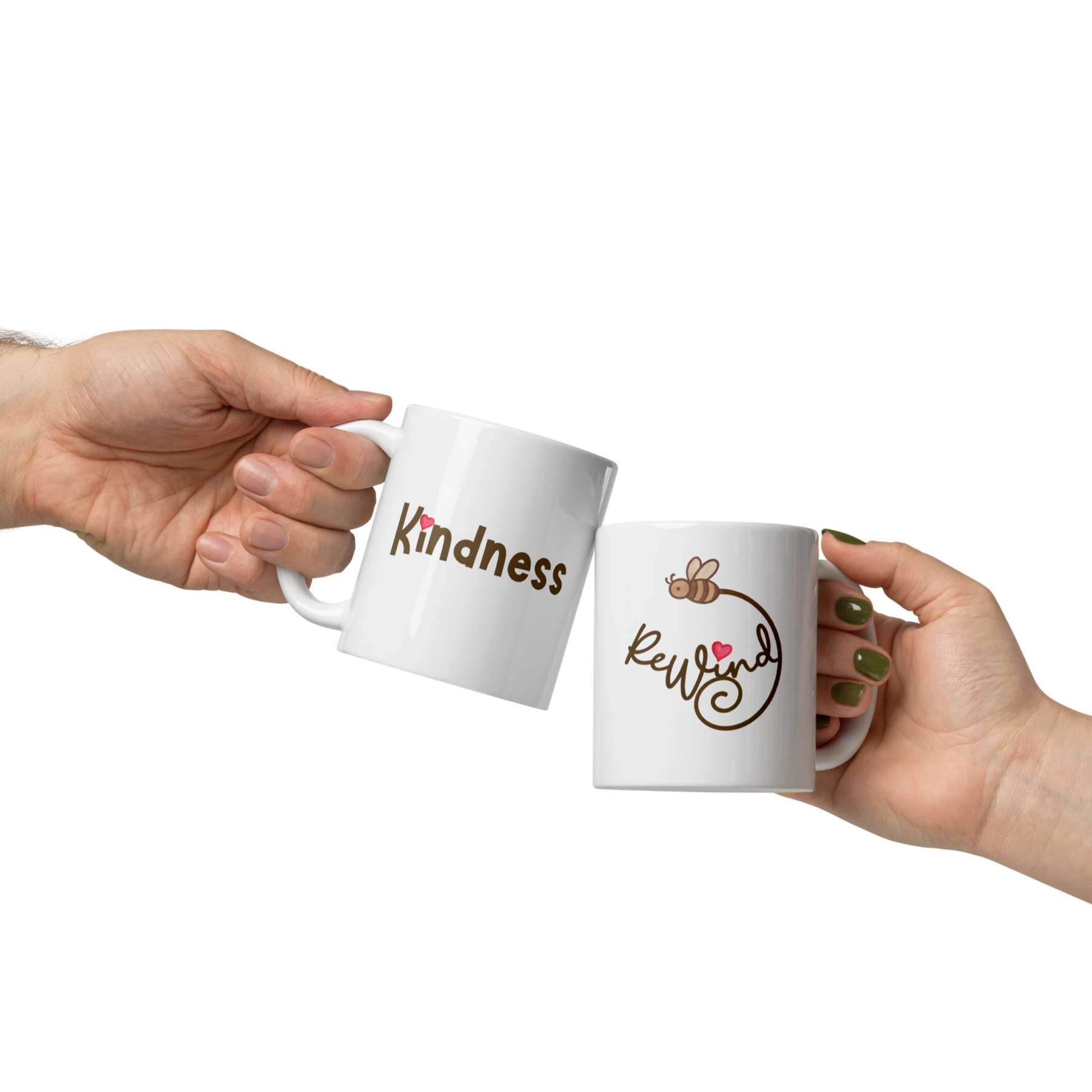 Two white ceramic mugs—one with the ReWind bee-heart logo and one with “Kindness”—held in hands; ReWind Kindness logo mugs.