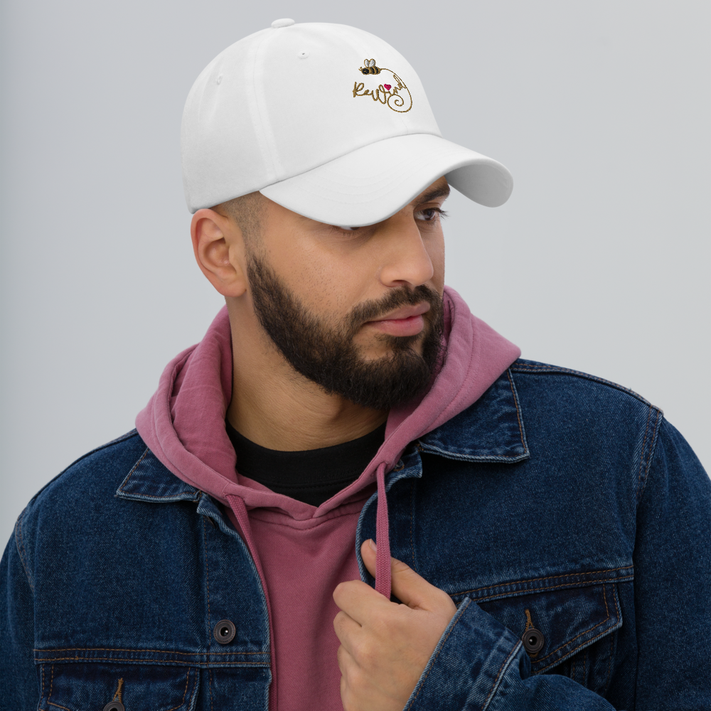 Model wearing white classic dad hat with embroidered ReWind bee-and-heart logo.