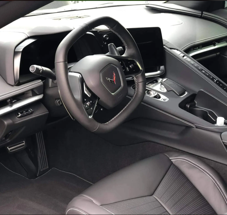 Interior of a Chevrolet Corvette with a sporty steering wheel, digital dashboard, and modern center console.