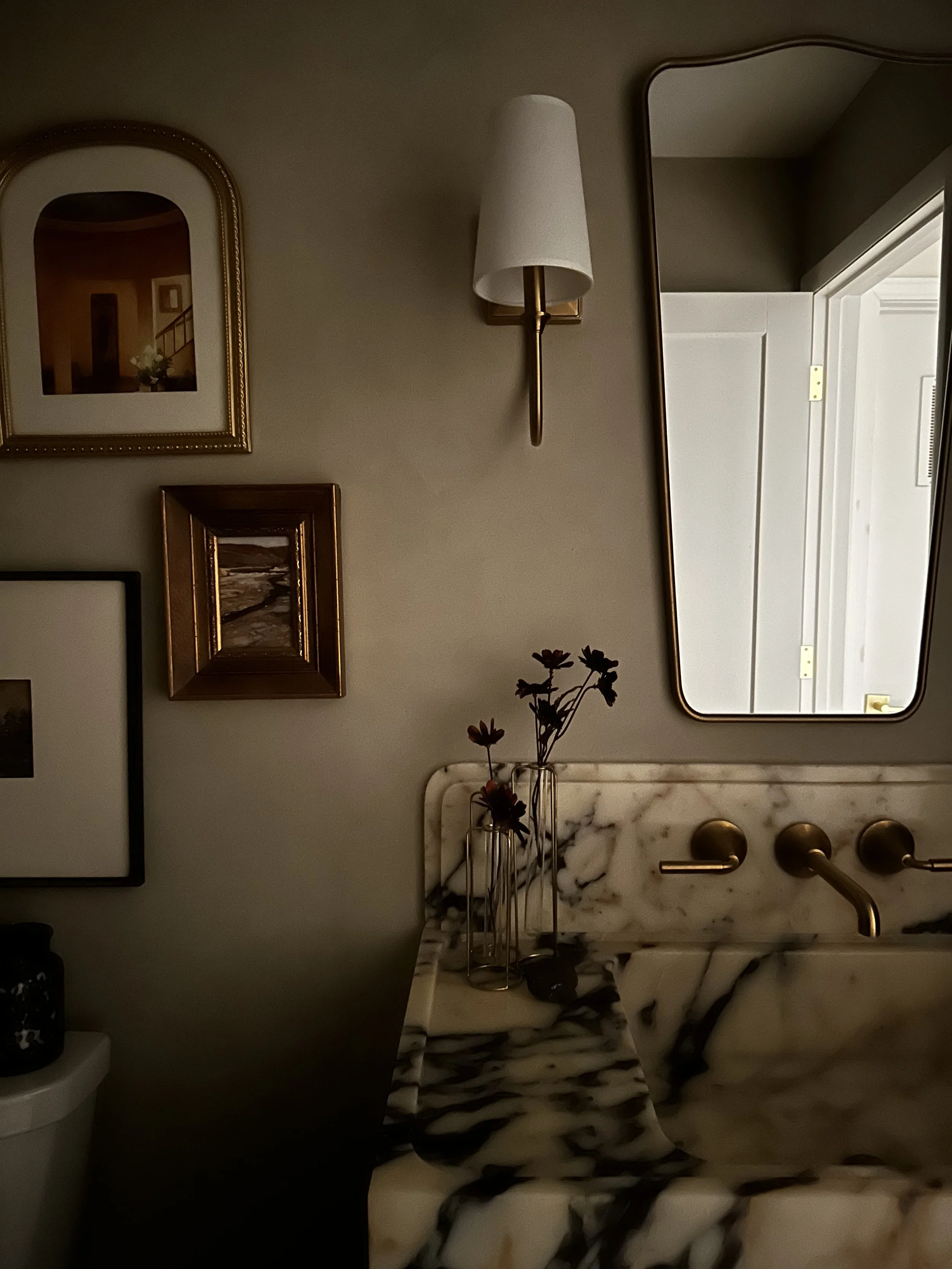 moody modern organic bathroom renovation, remodel, interior design, limewash walls, calacatta violi marble vanity, gallery wall antique art, vintage florals, gold asymmetrical mirror, gold wall sconces with white shades