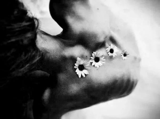 Um desenho em preto e branco de uma pessoa com flores no cabelo