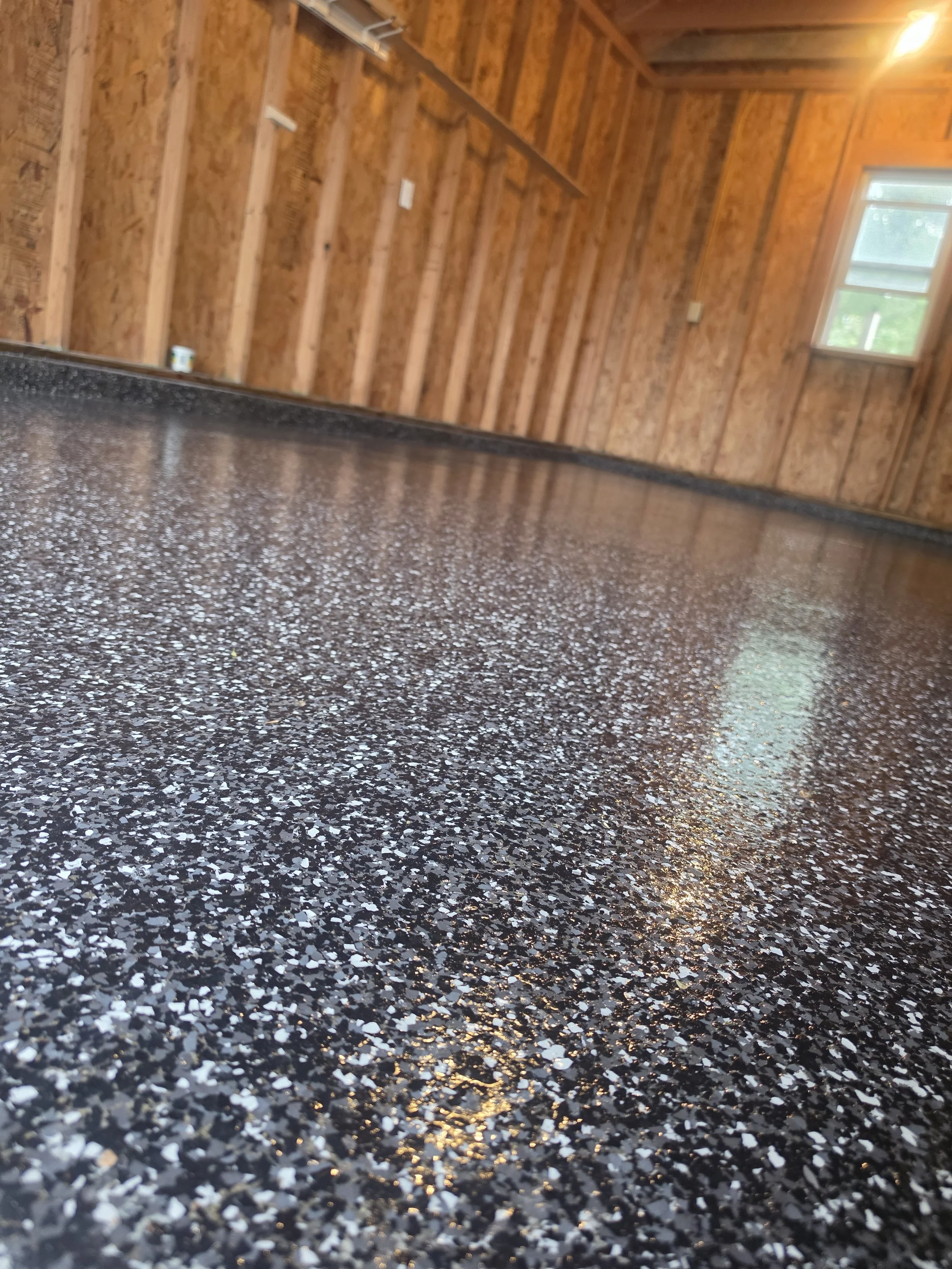 Finished residential garage floor with a full-flake coating installed by Forge Surfaces