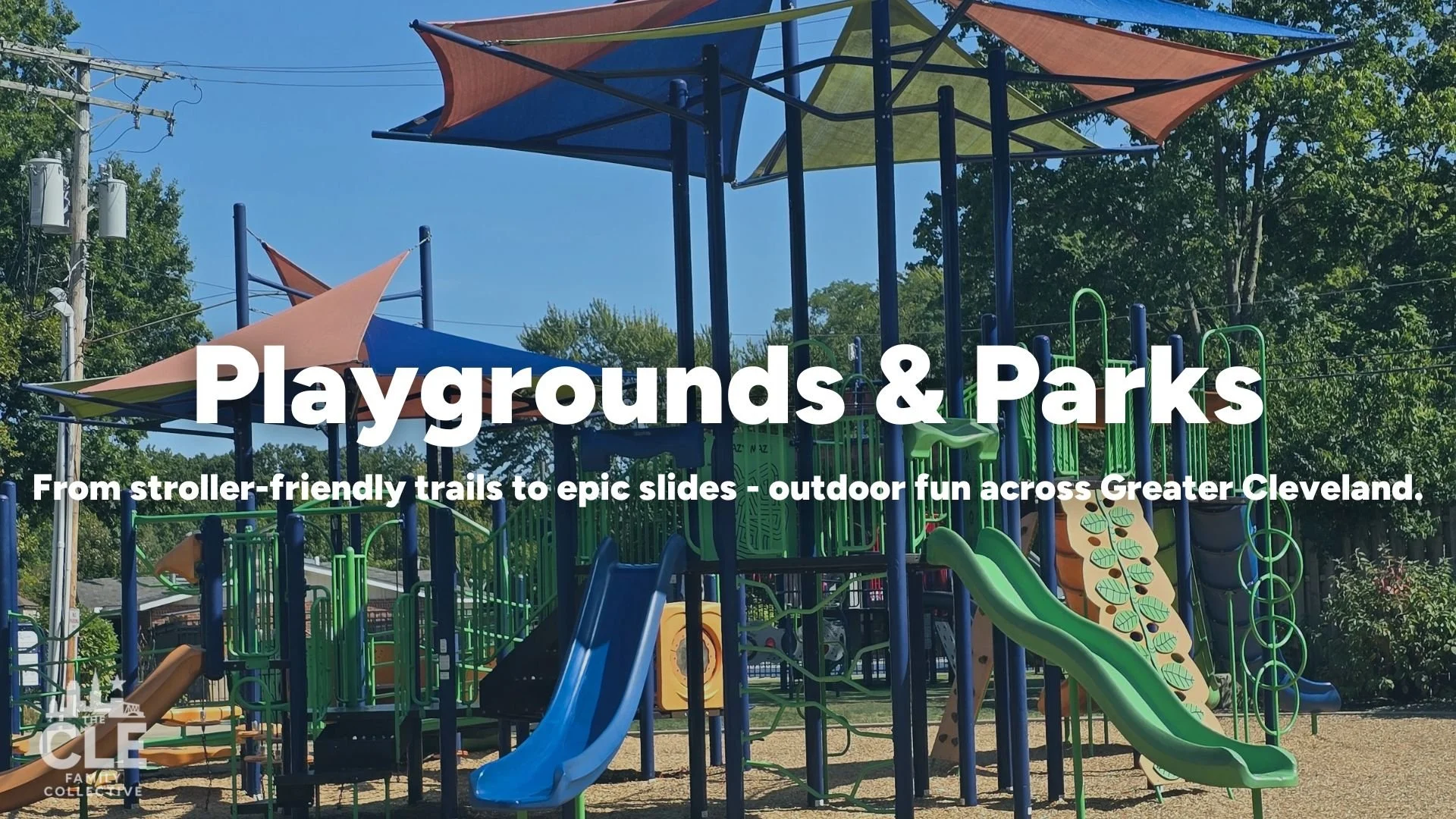 A colorful playground with multiple slides, climbing structures, and shade sails in a park setting, surrounded by trees.