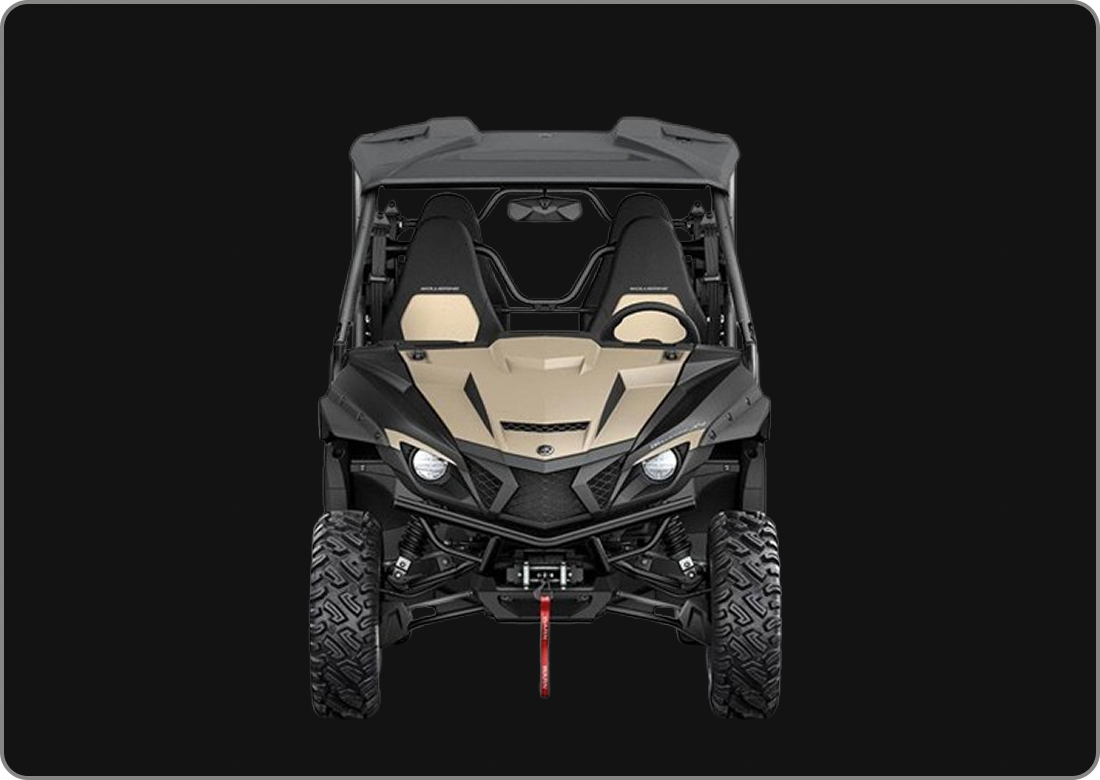 Front view of a black and beige off-road utility vehicle with large tires and a roll cage against a black background.