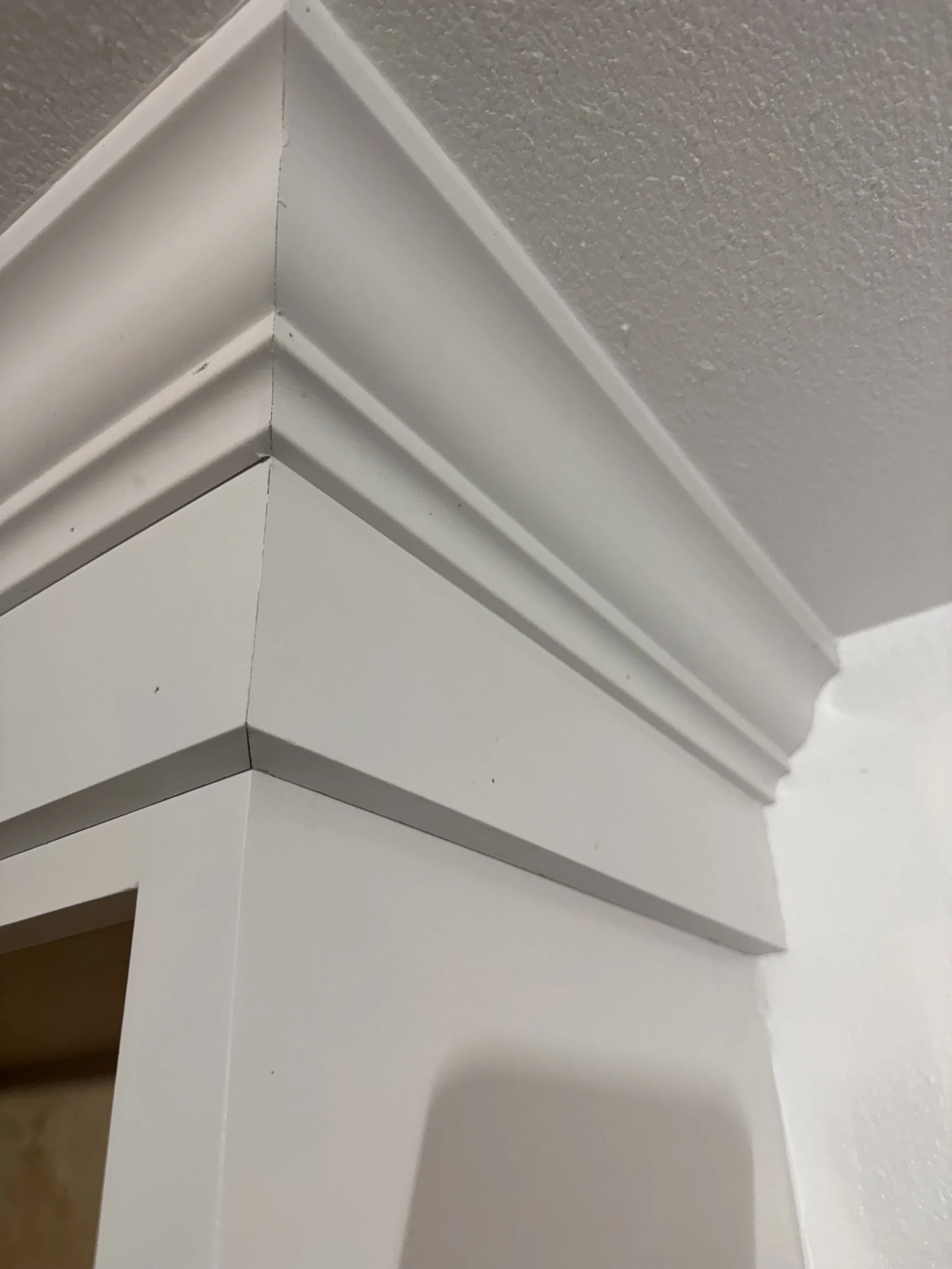 Close-up of white crown molding at the corner where the wall and ceiling meet.