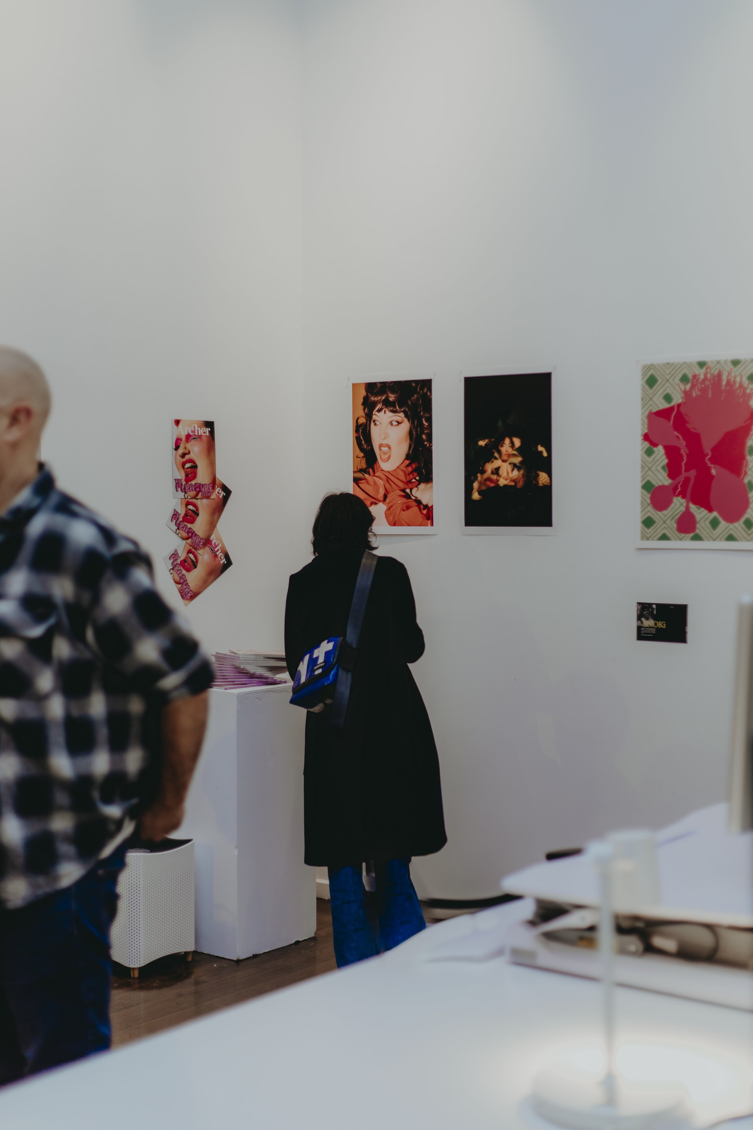 People viewing artwork and photographs in an art gallery or exhibit