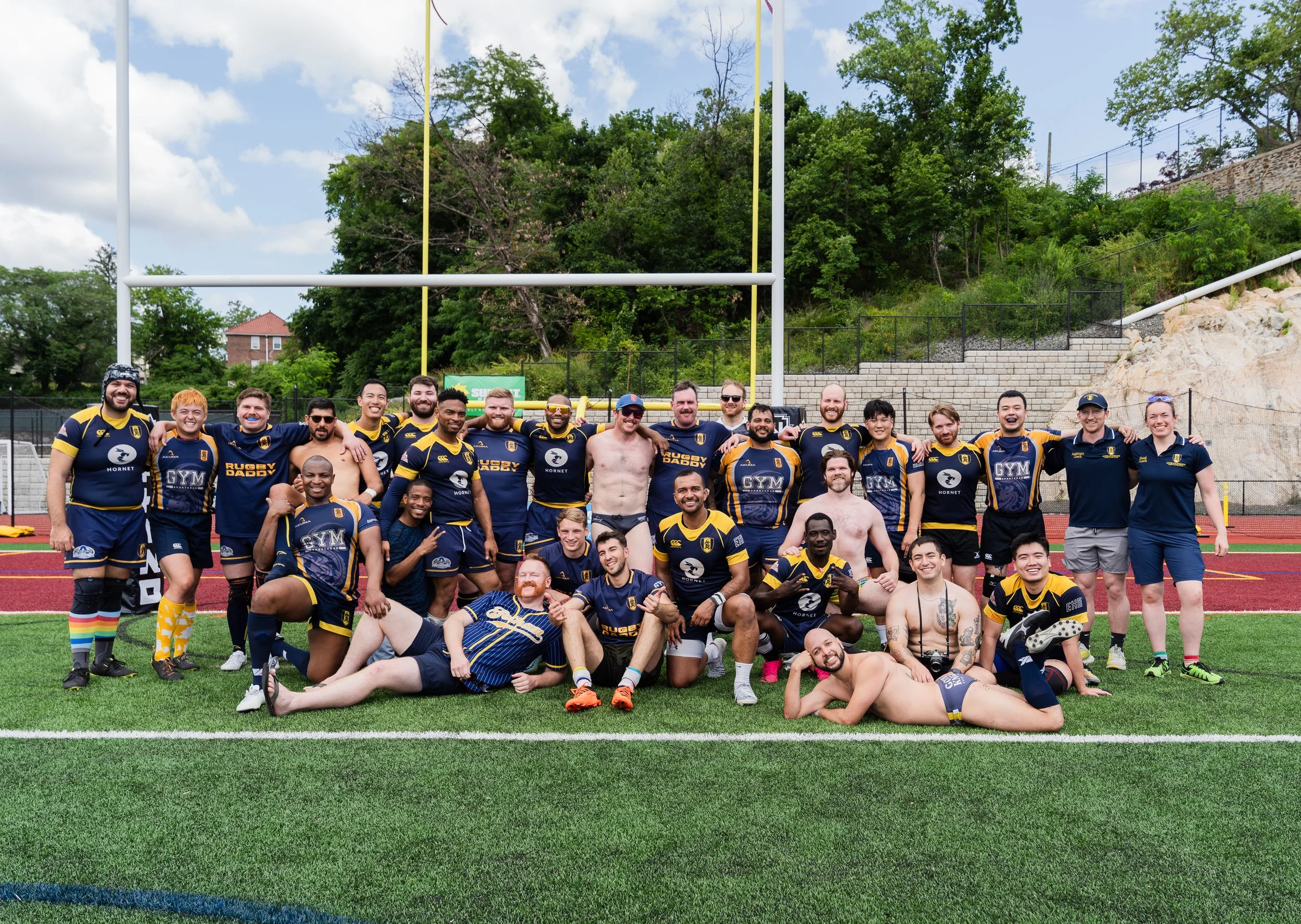 The full Gotham Knights squad posing together under the posts on a turf pitch after a match.