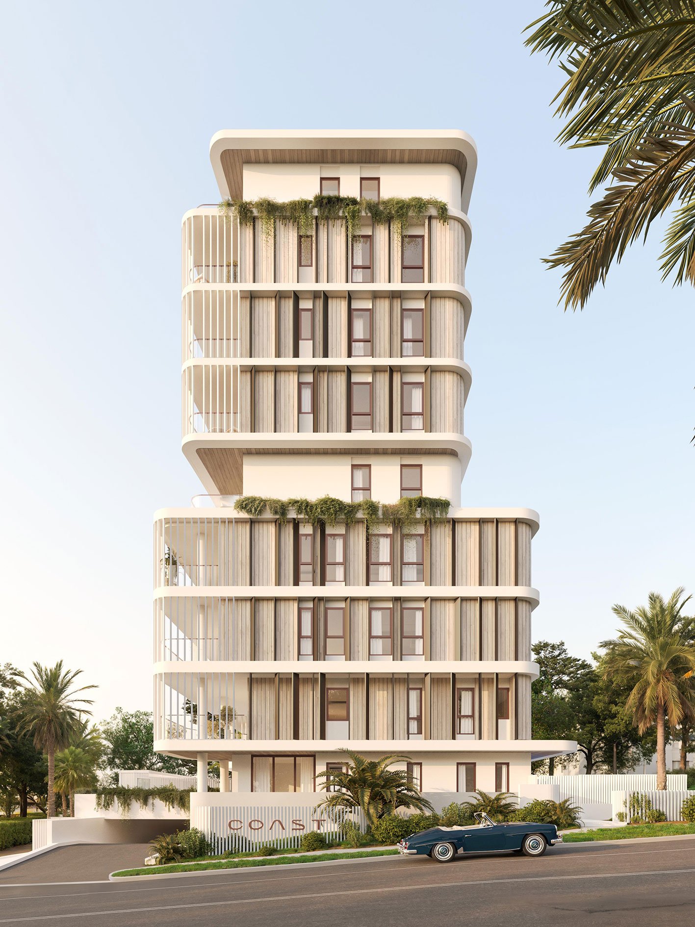 Modern multi-story residential building with curved balconies, greenery, and large windows, situated on a palm-lined street with a vintage blue convertible parked in front.